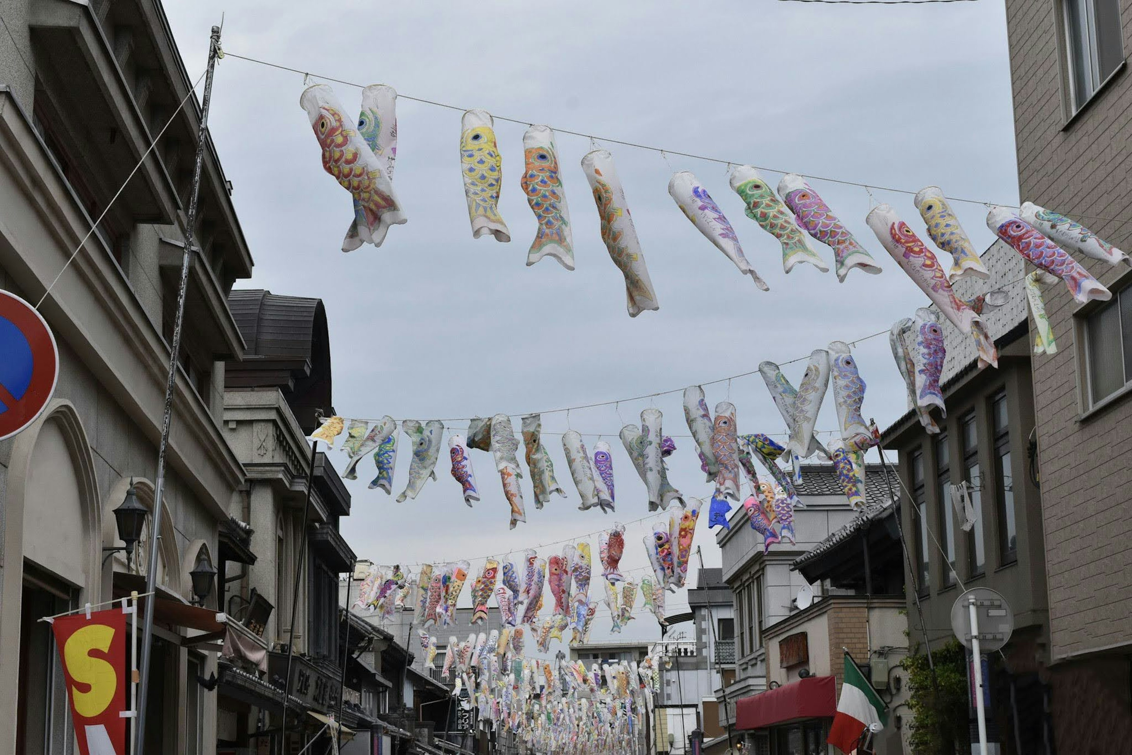 Banderas de koi coloridas colgadas sobre una calle comercial