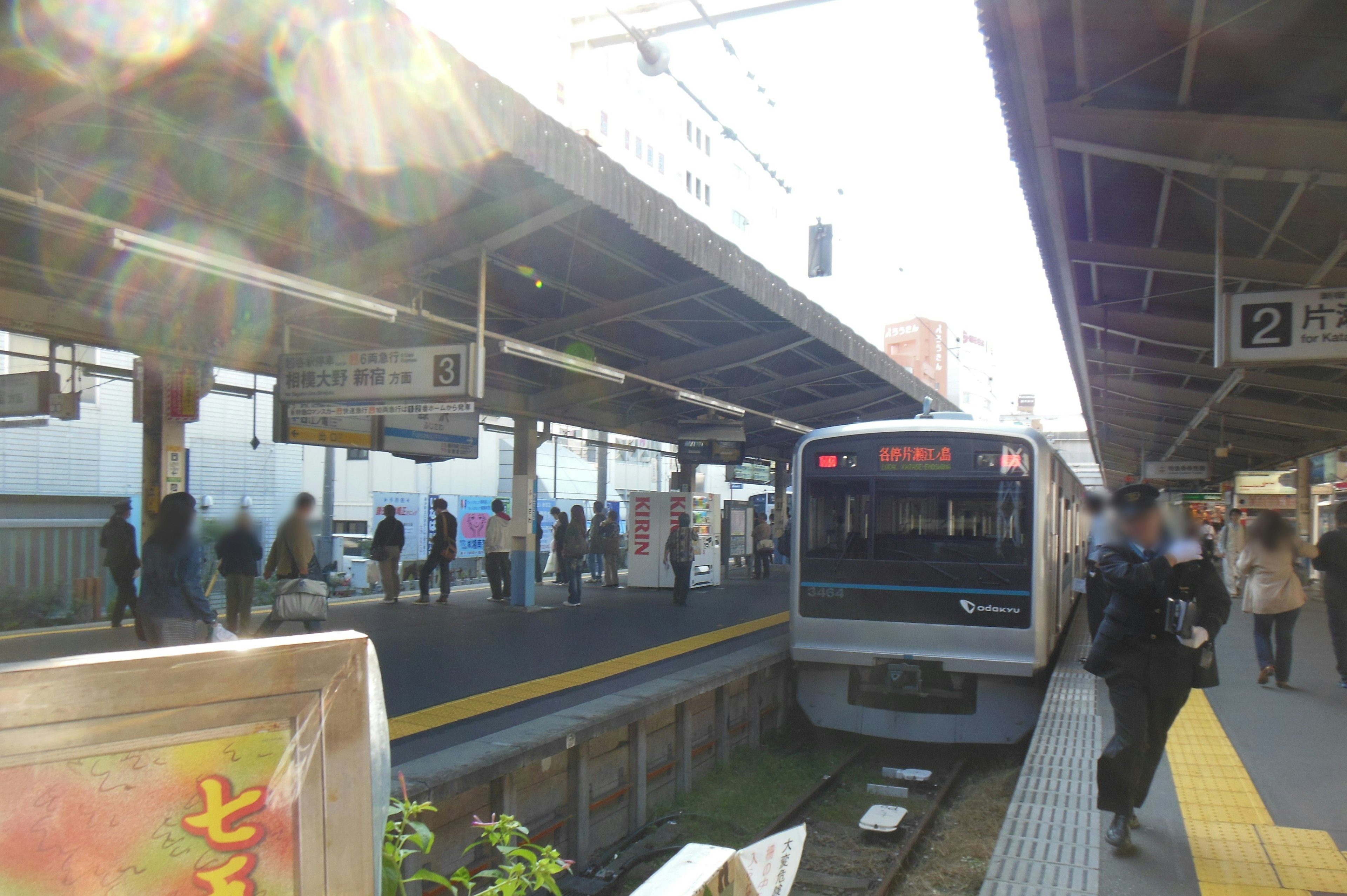 Pasajeros en una plataforma de tren con un tren