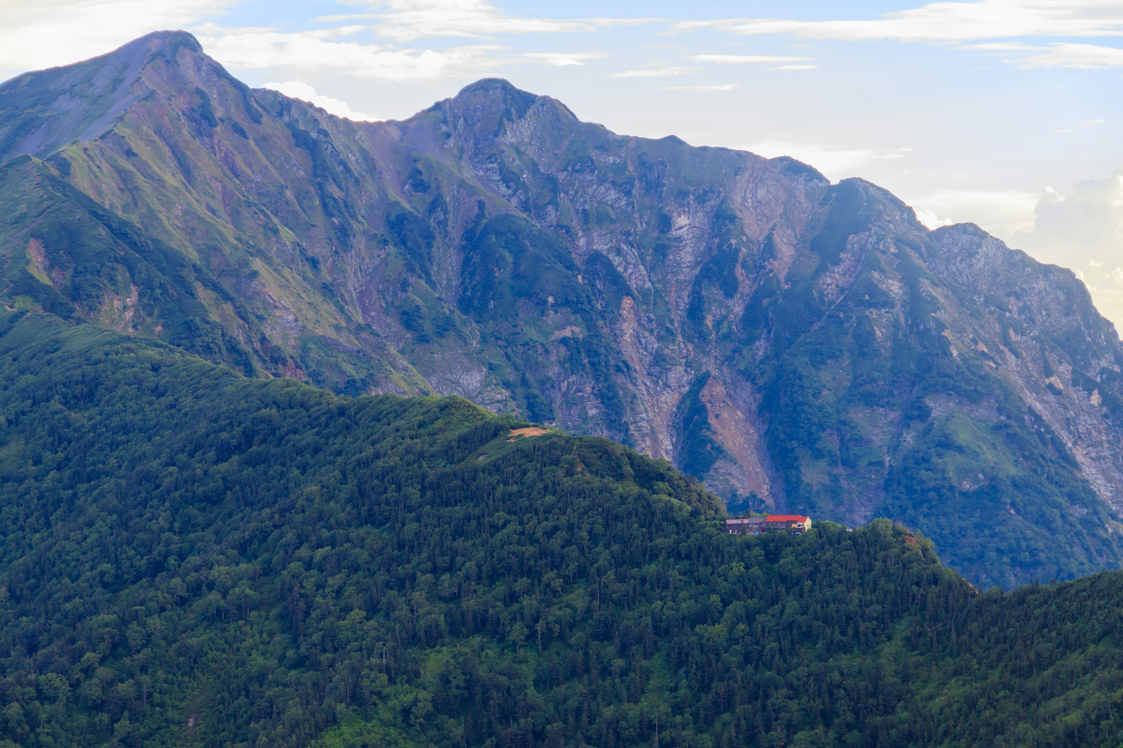 緑豊かな山々と岩の多い山脈が広がる風景