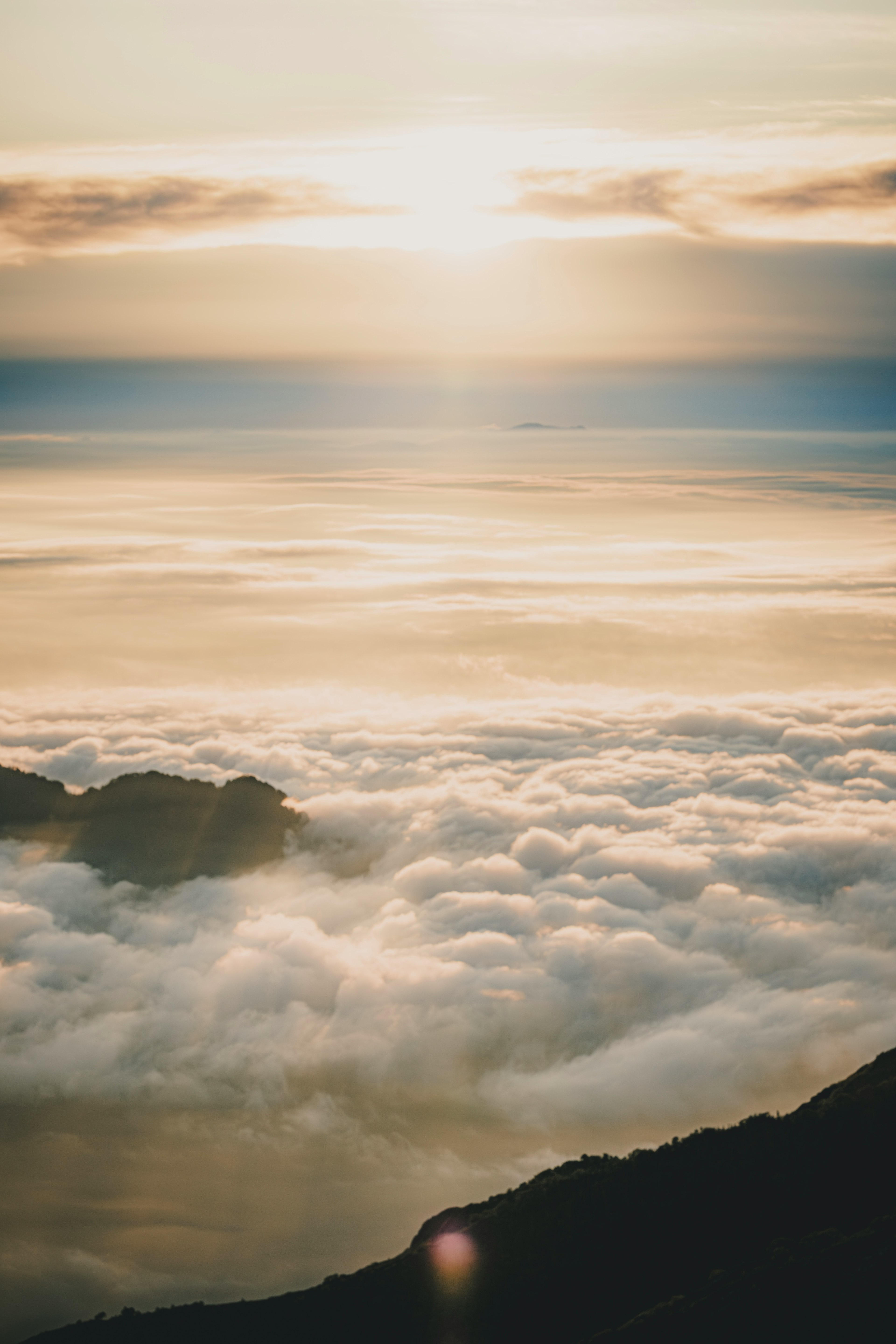 Sunrise over a sea of clouds with mountain silhouette