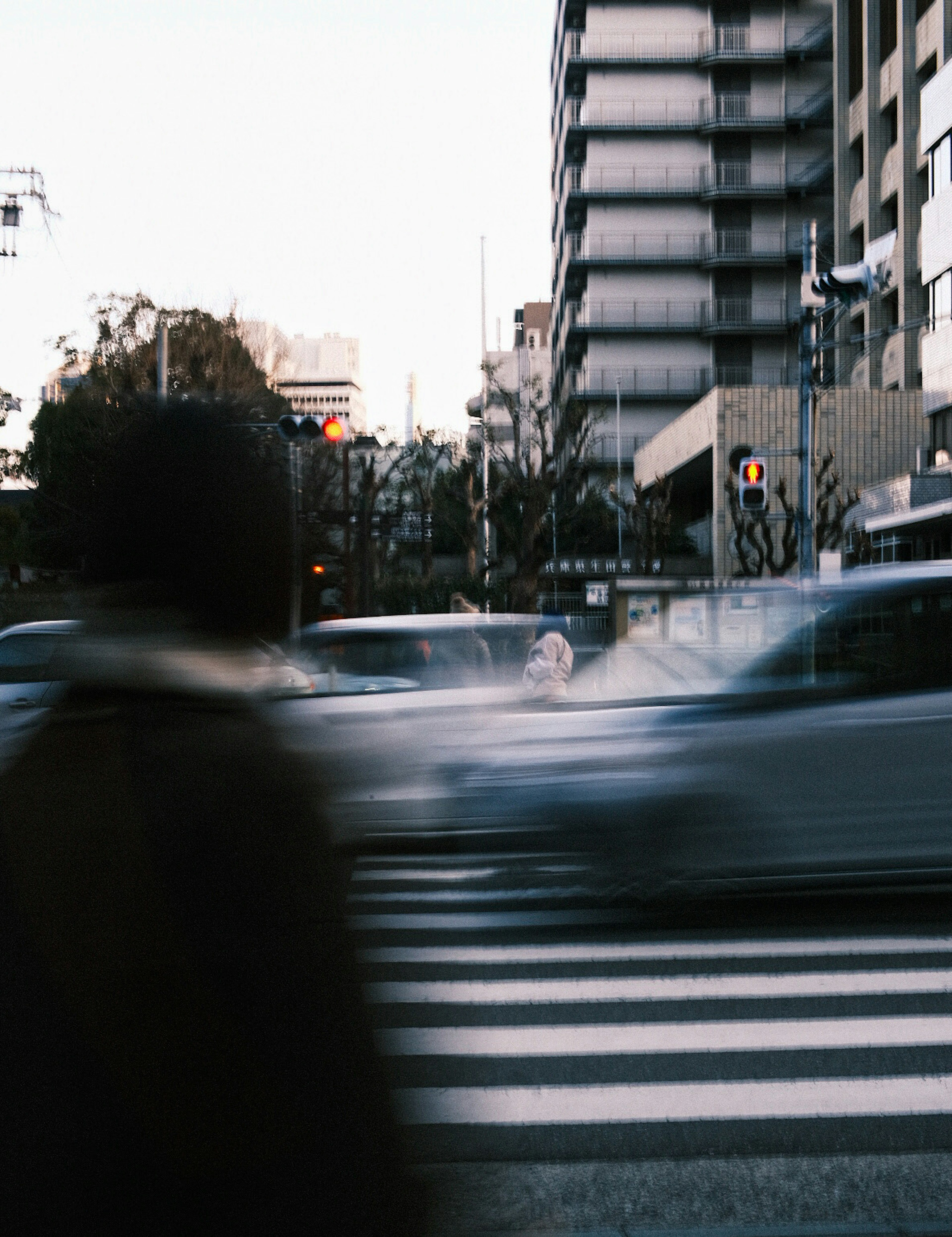 Immagine che cattura auto e pedoni in movimento a un incrocio urbano