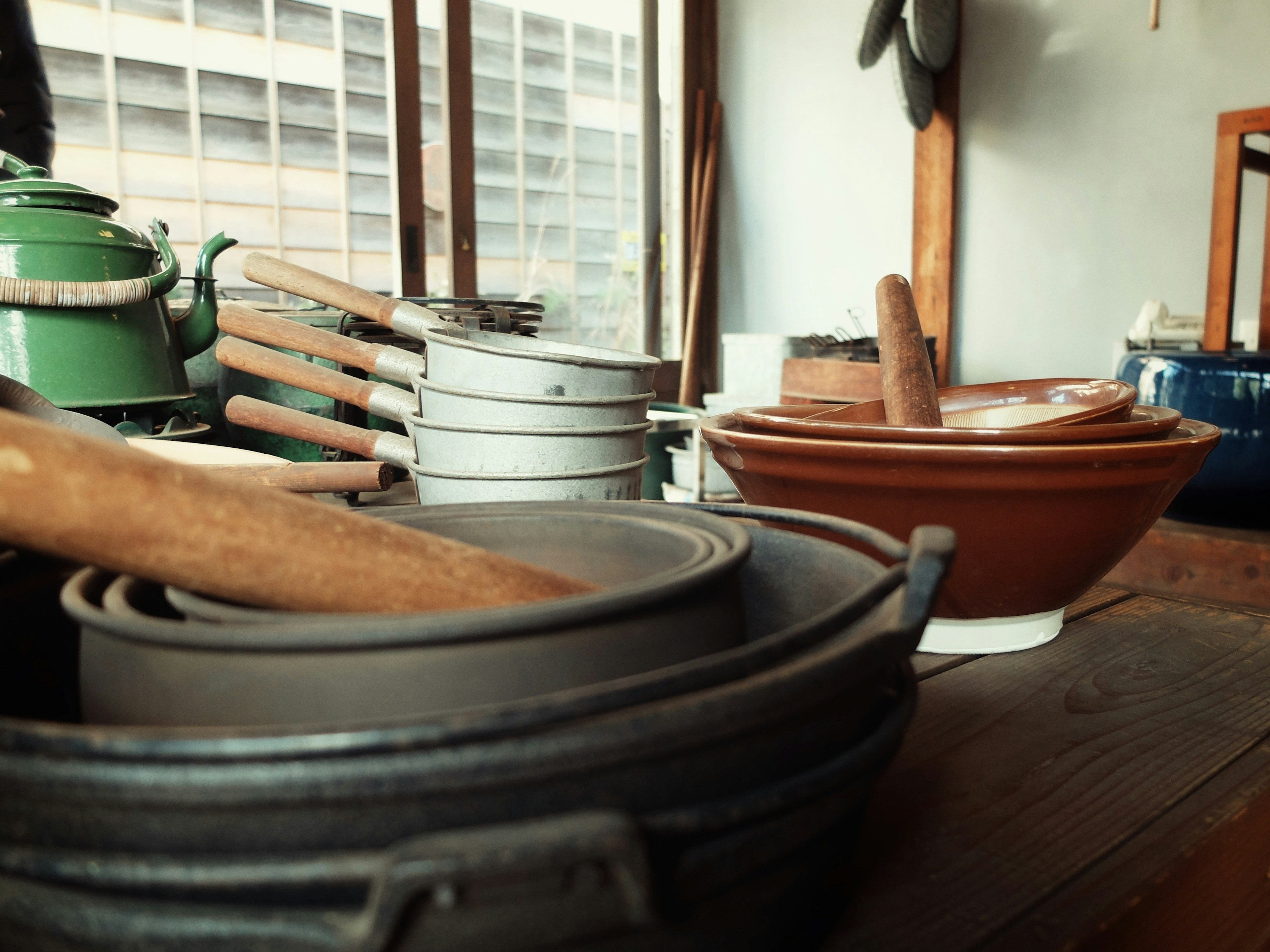 Various pots and wooden spoons arranged near a window