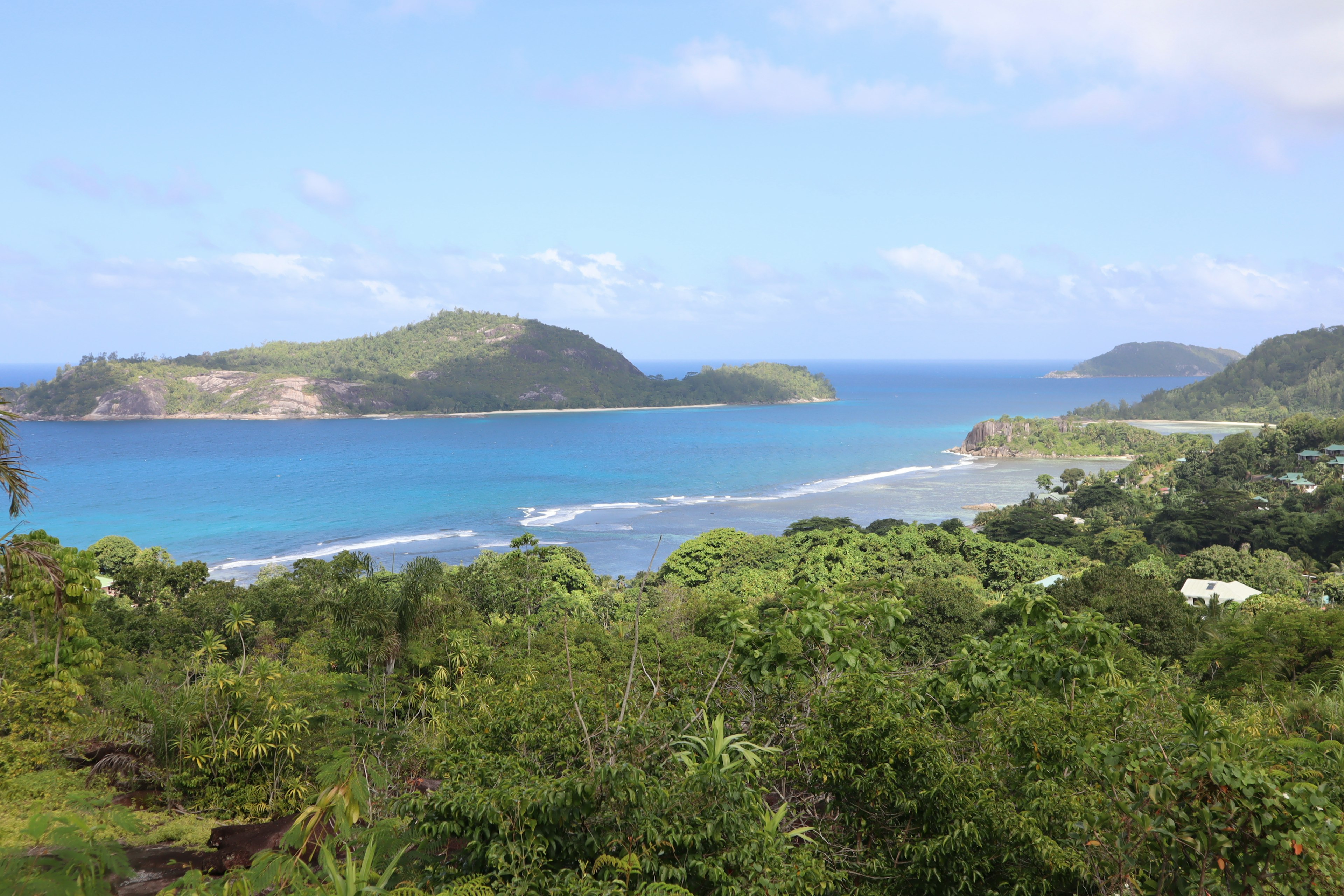 Scenic view of lush green hills and tranquil blue ocean