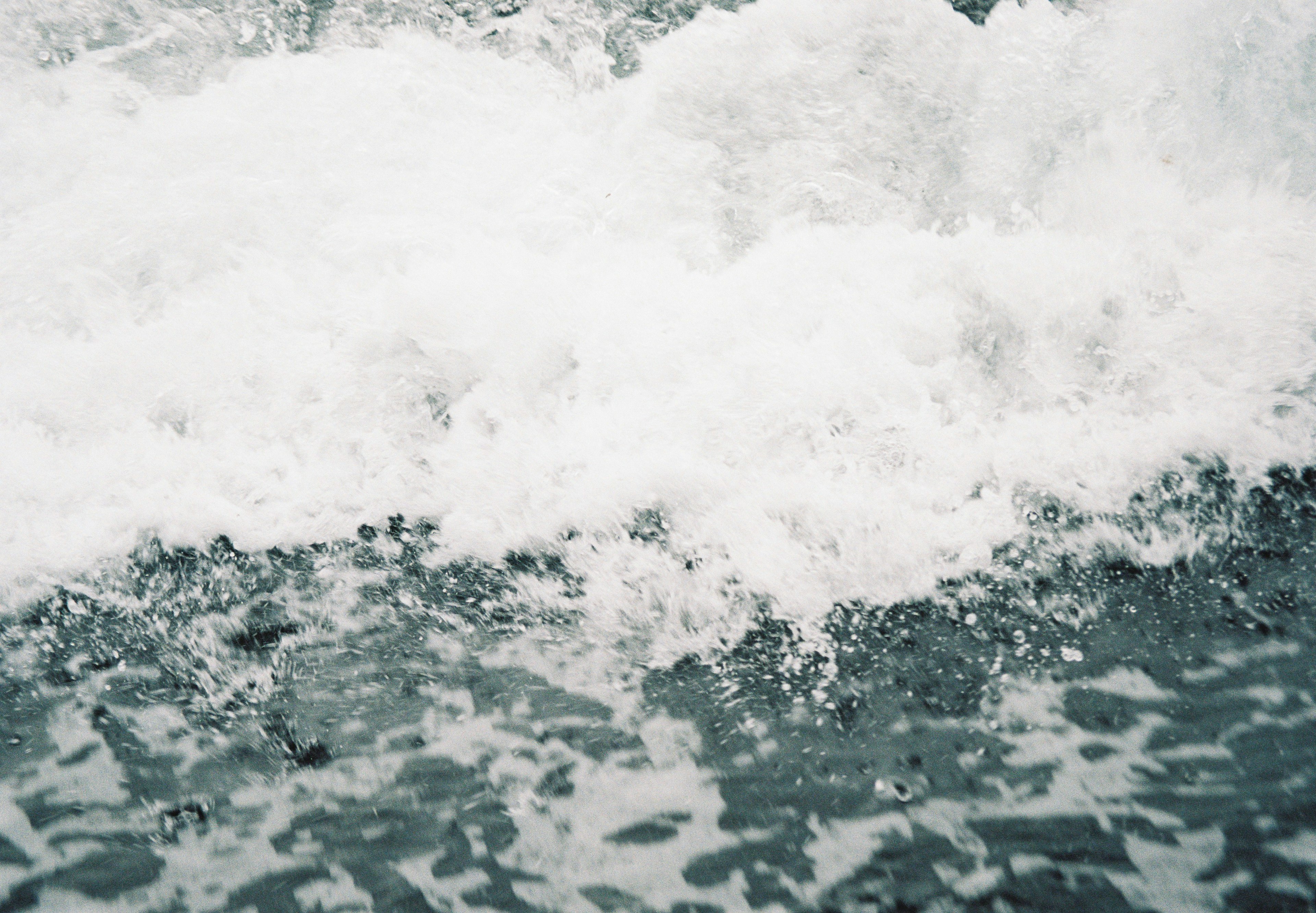 Nahaufnahme von Ozeanwellen mit weißem Schaum und dunkelblauem Wasser