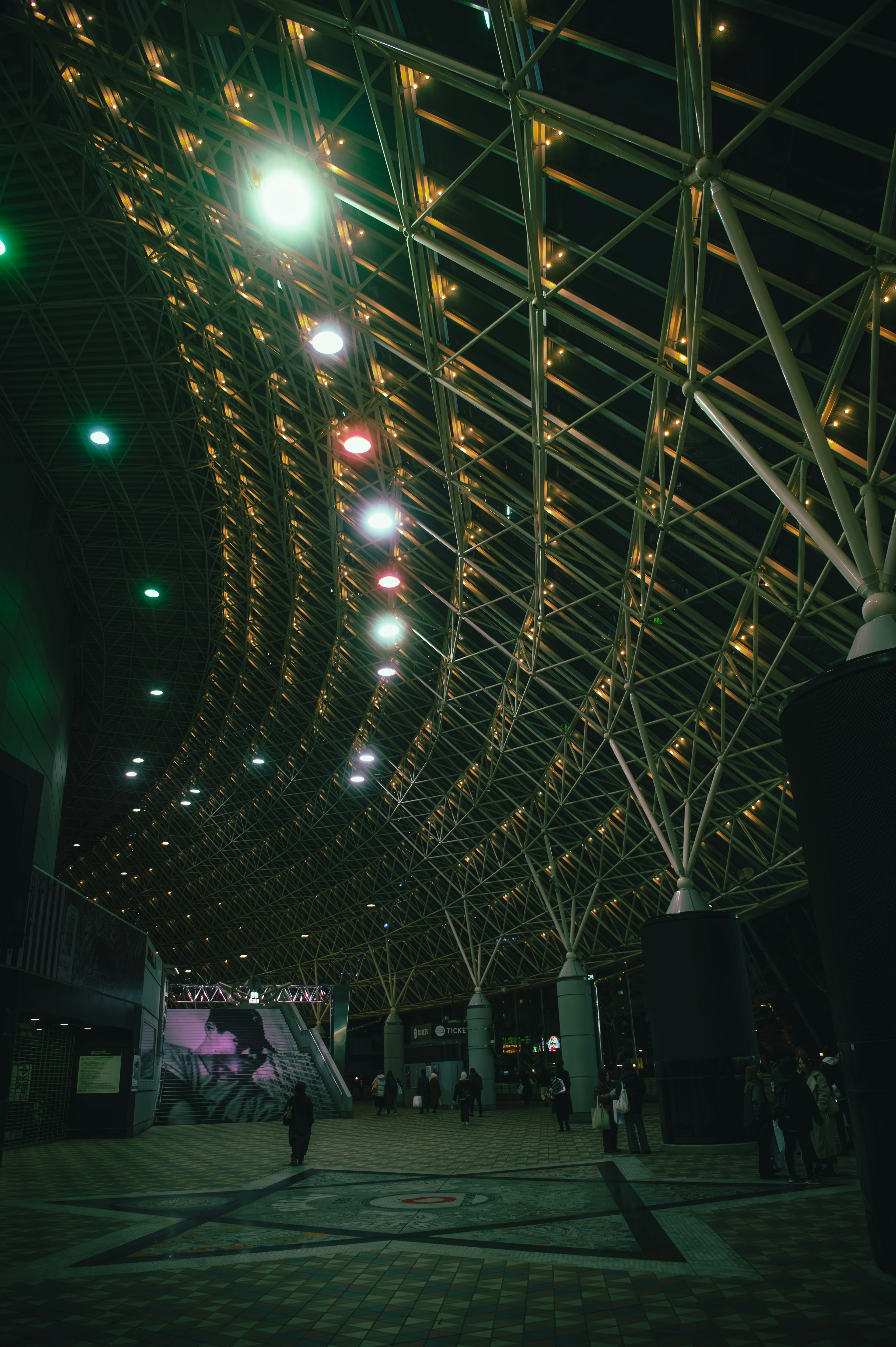 Curved architectural structure with colorful lights in a dark space