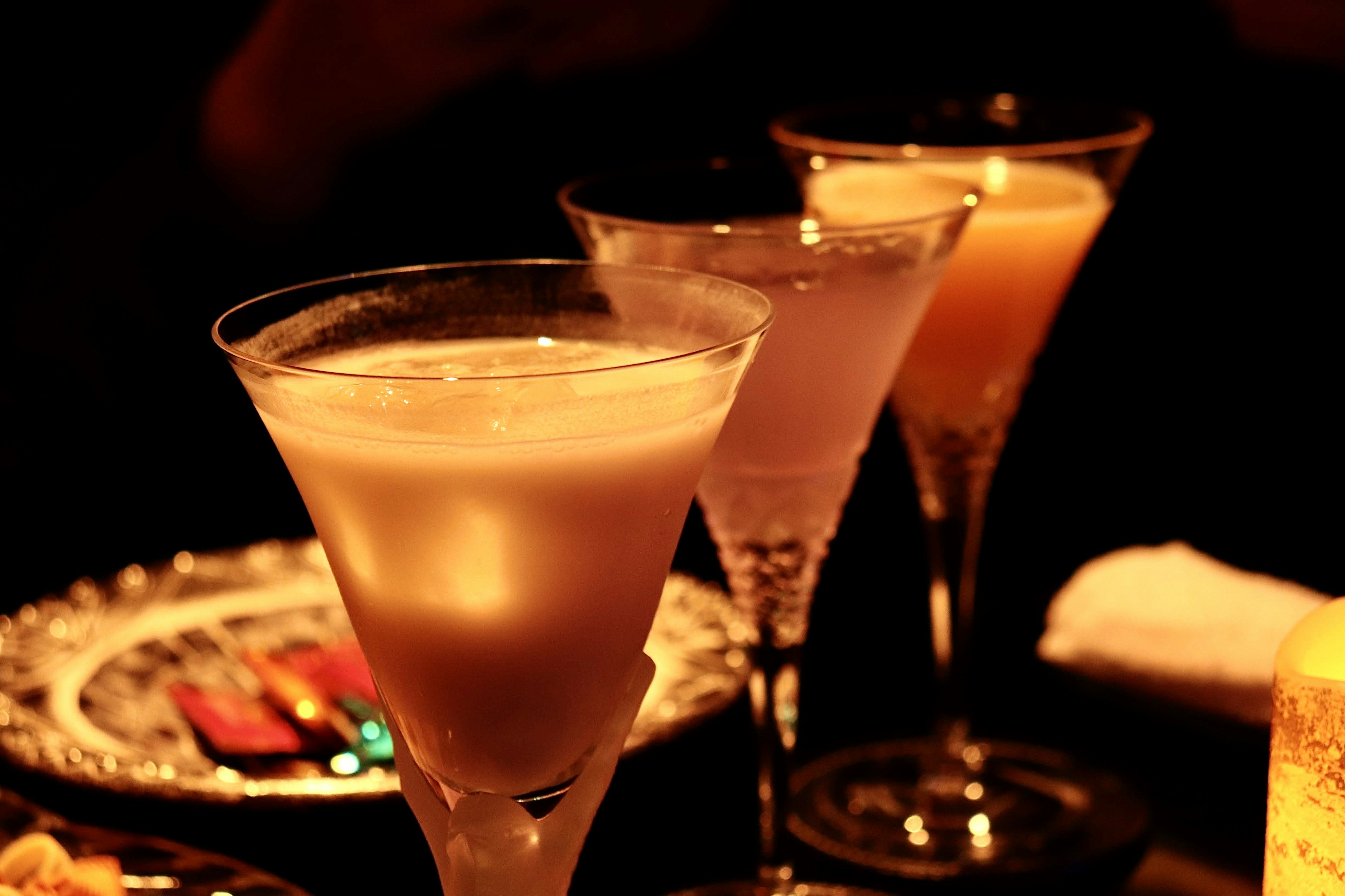 Cocktail glasses with light drinks on a dark background