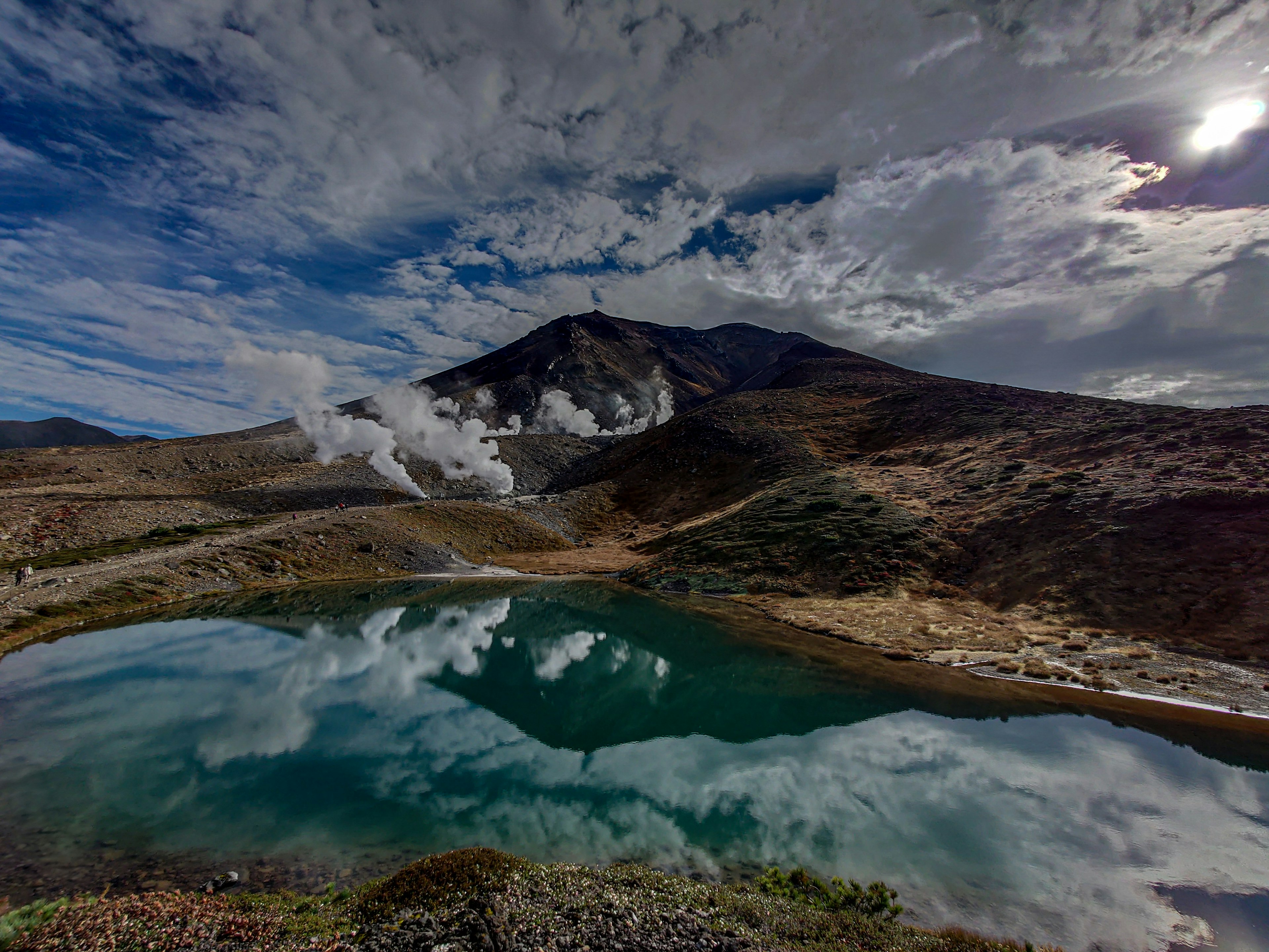 Vista panoramica di un vulcano e del suo riflesso in un lago tranquillo