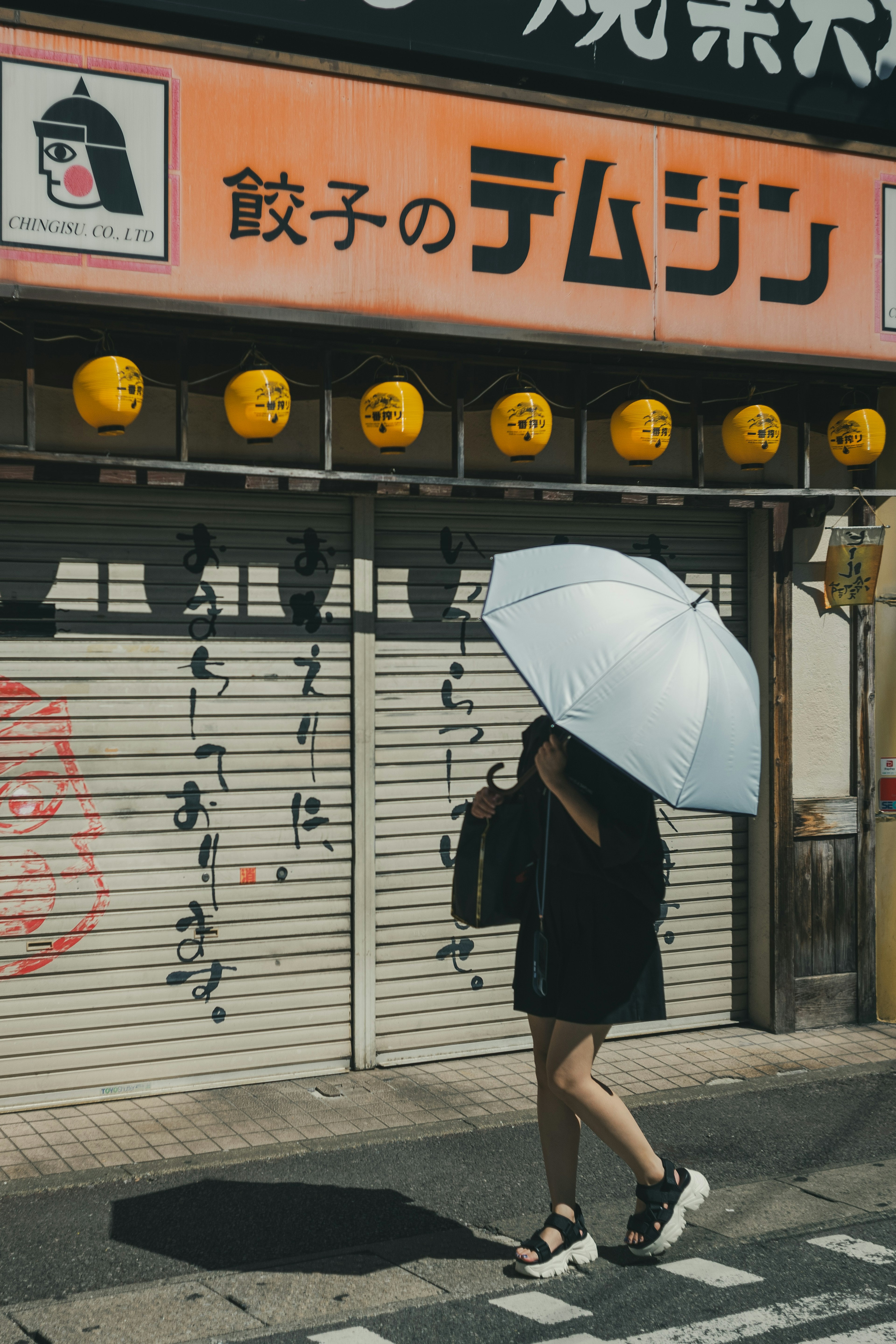 Une femme marchant avec un parapluie blanc dans un cadre urbain