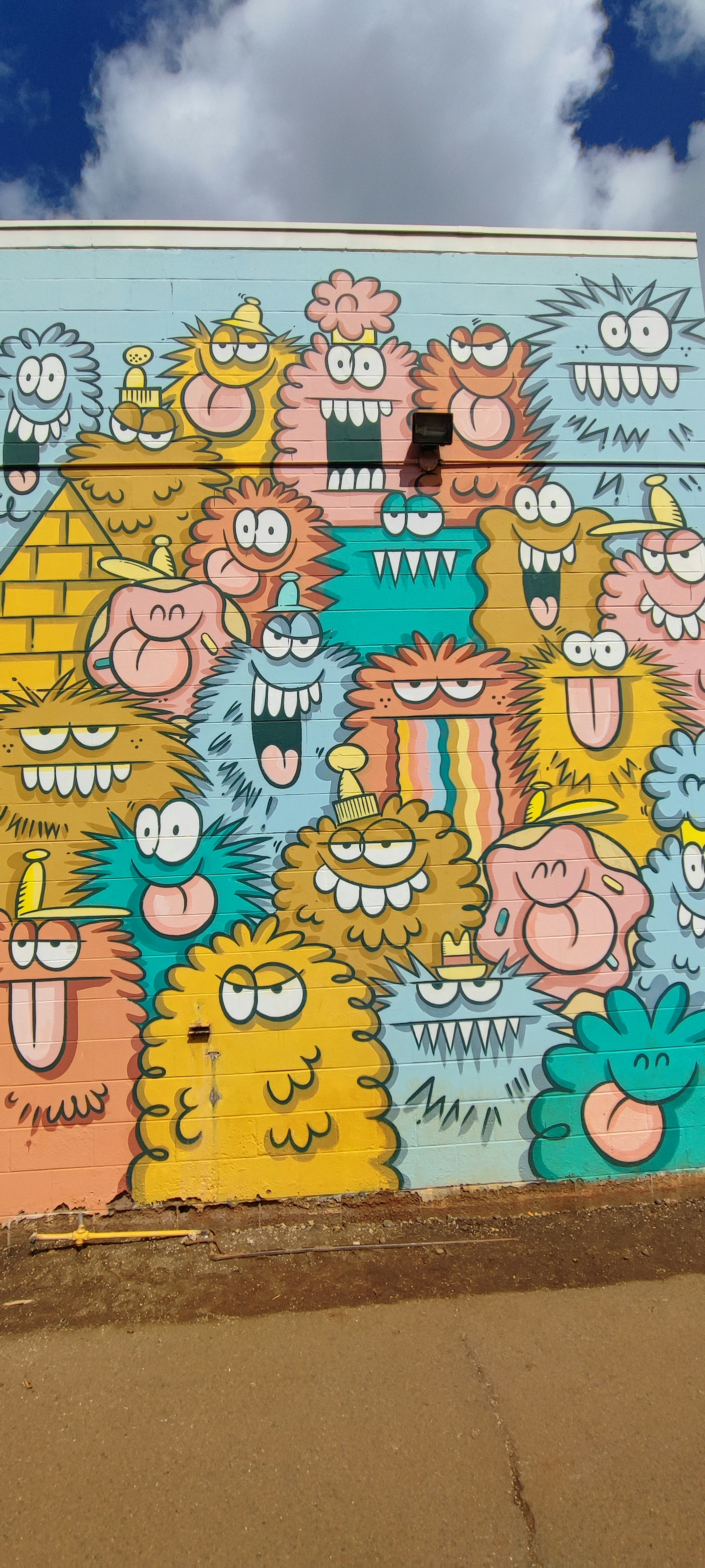 Colorful mural featuring quirky monster characters with expressive faces