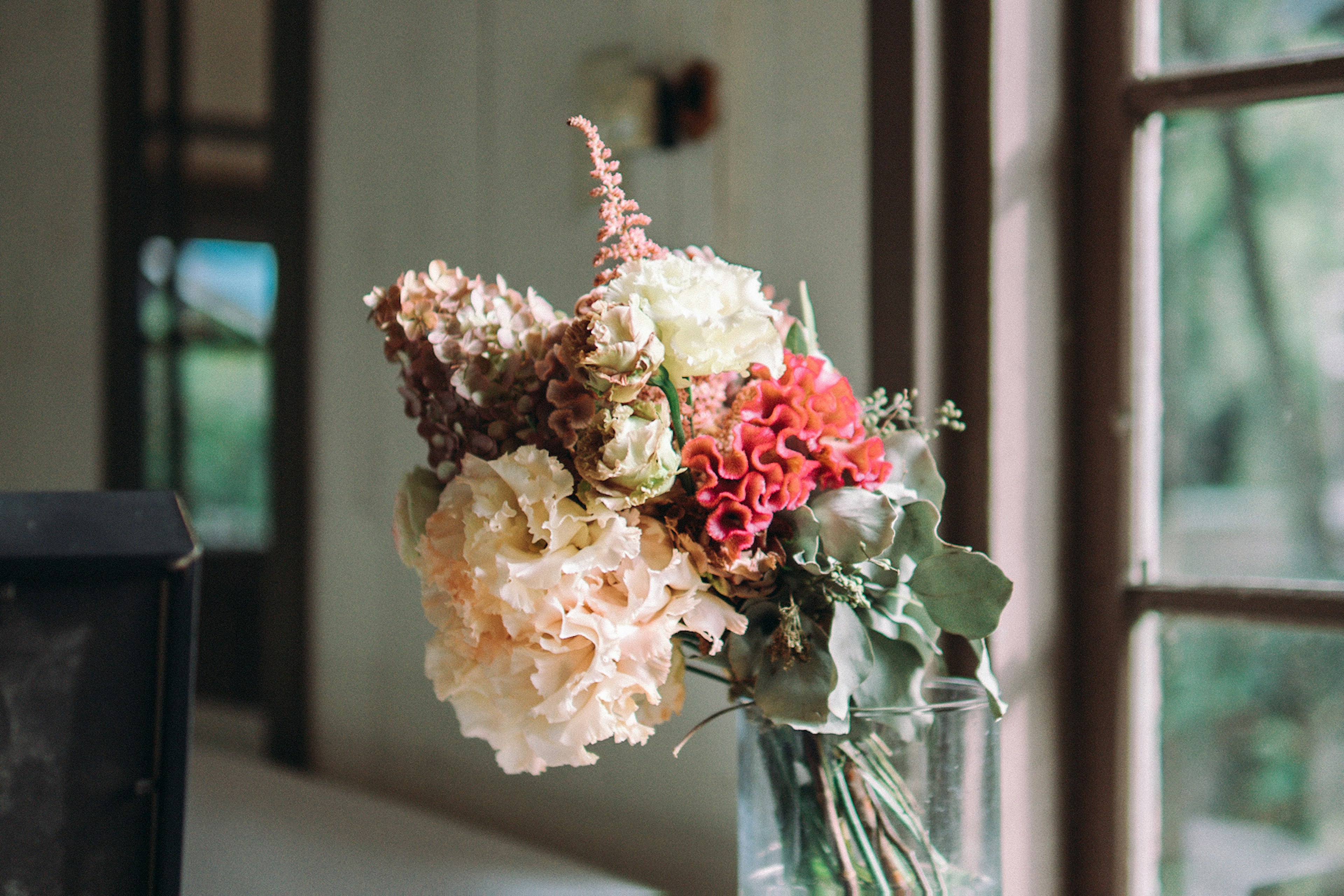 Un colorido ramo de flores secas en un jarrón de vidrio