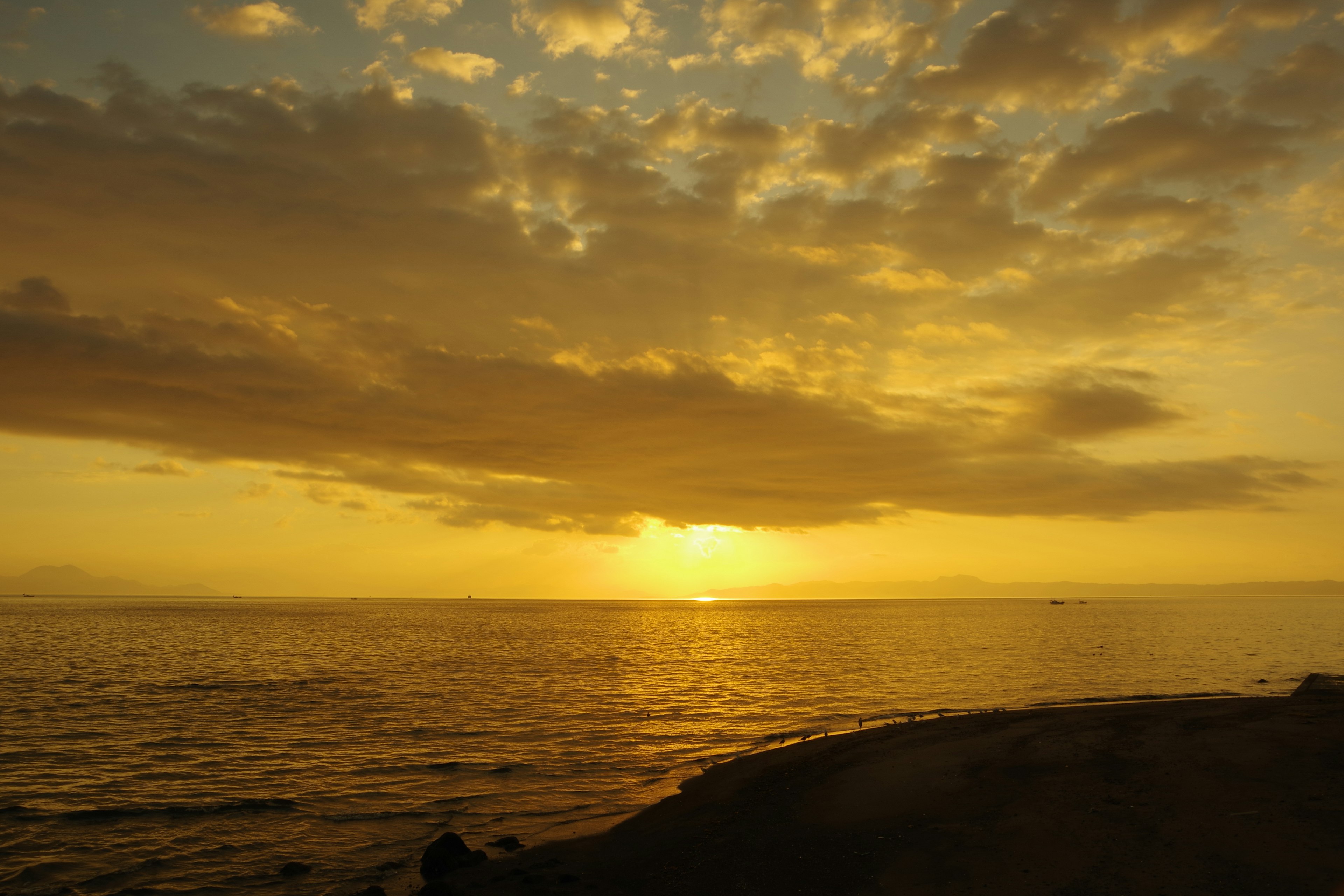 Pemandangan matahari terbenam yang indah di atas laut dengan awan oranye