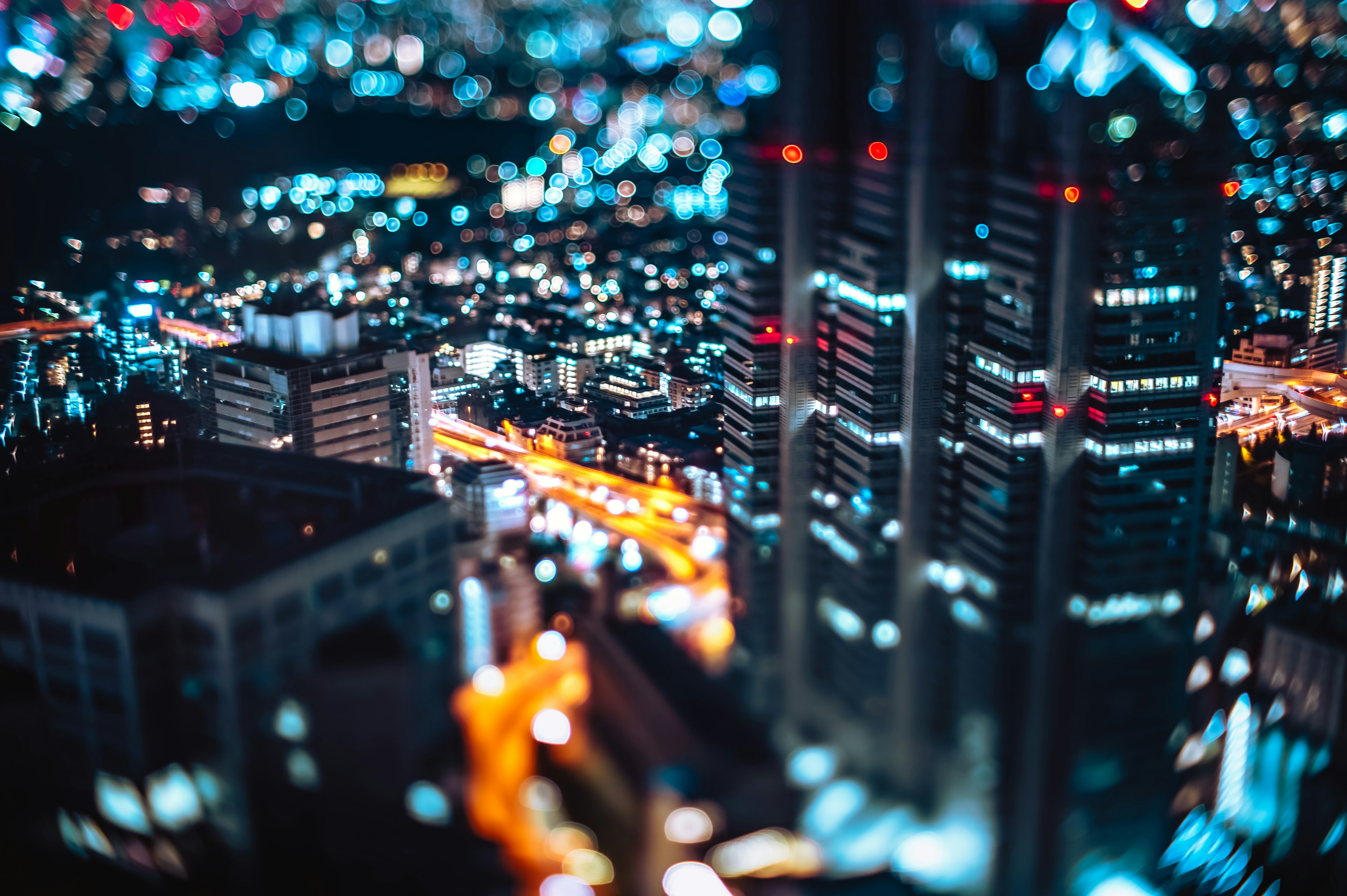 Vue nocturne floue d'une ville avec des gratte-ciels illuminés et des rues