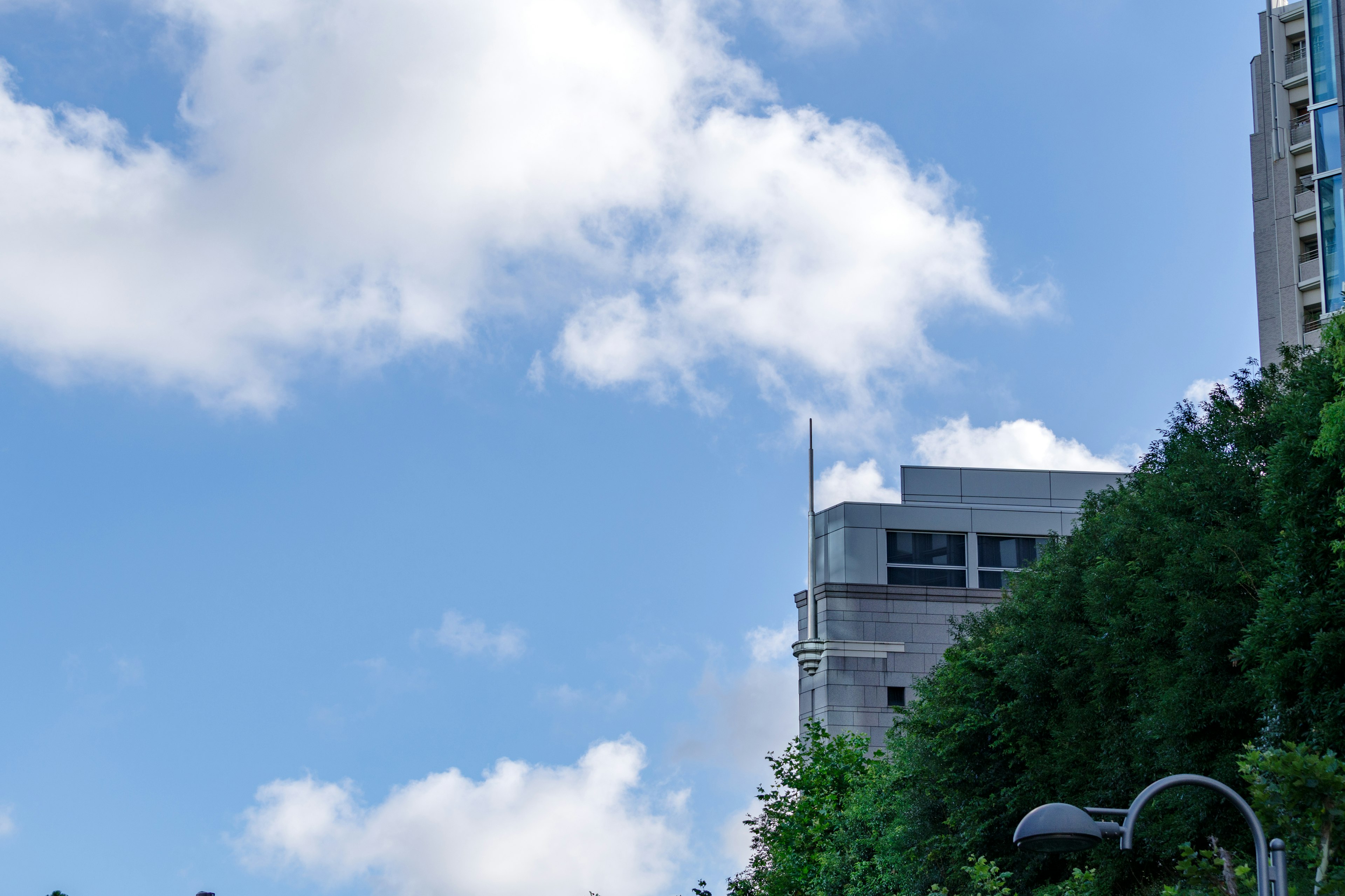 Teil eines Wolkenkratzers vor einem Hintergrund aus blauem Himmel und Wolken