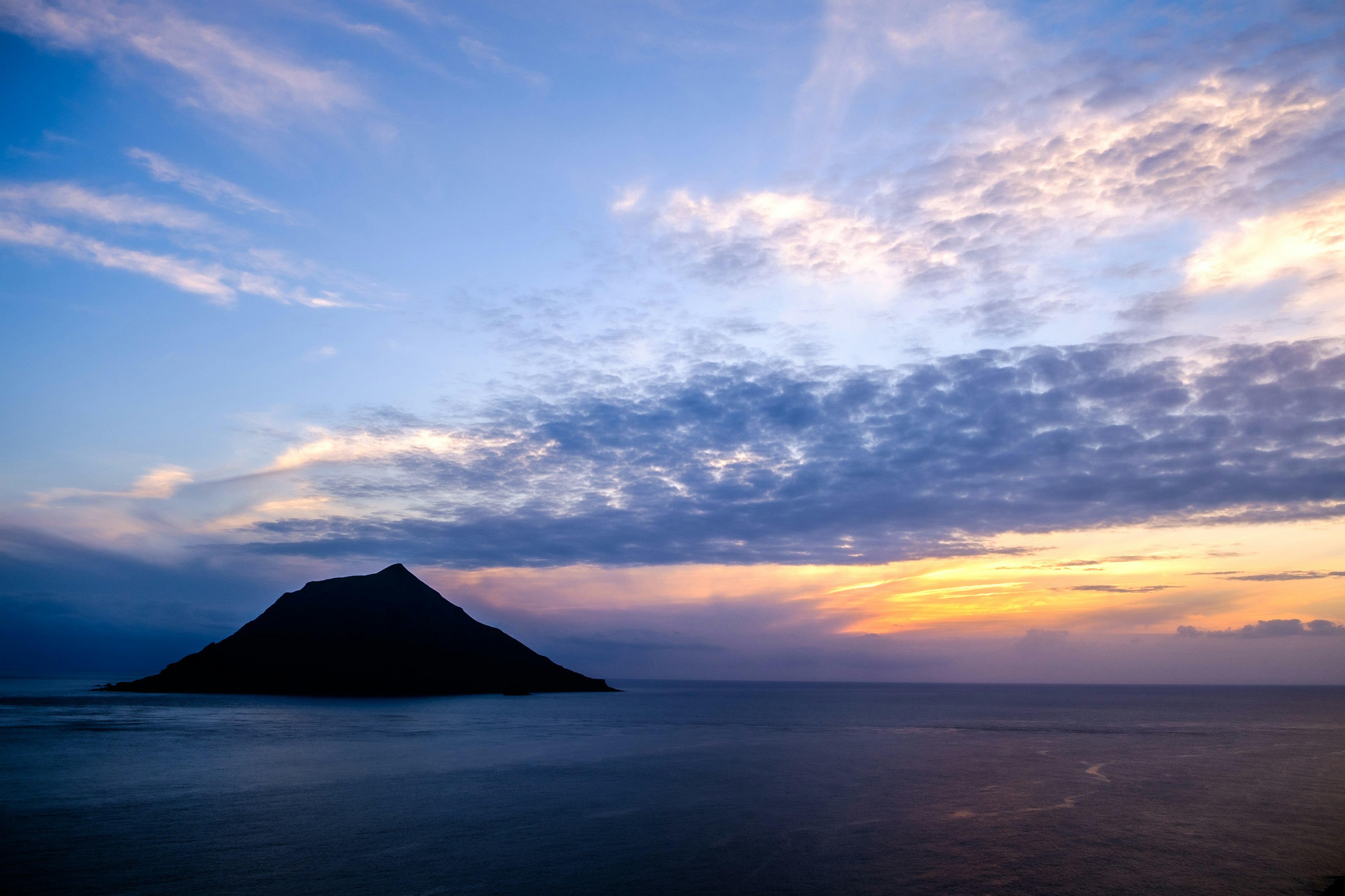 夕焼けの空を背景にした孤立した小島の風景