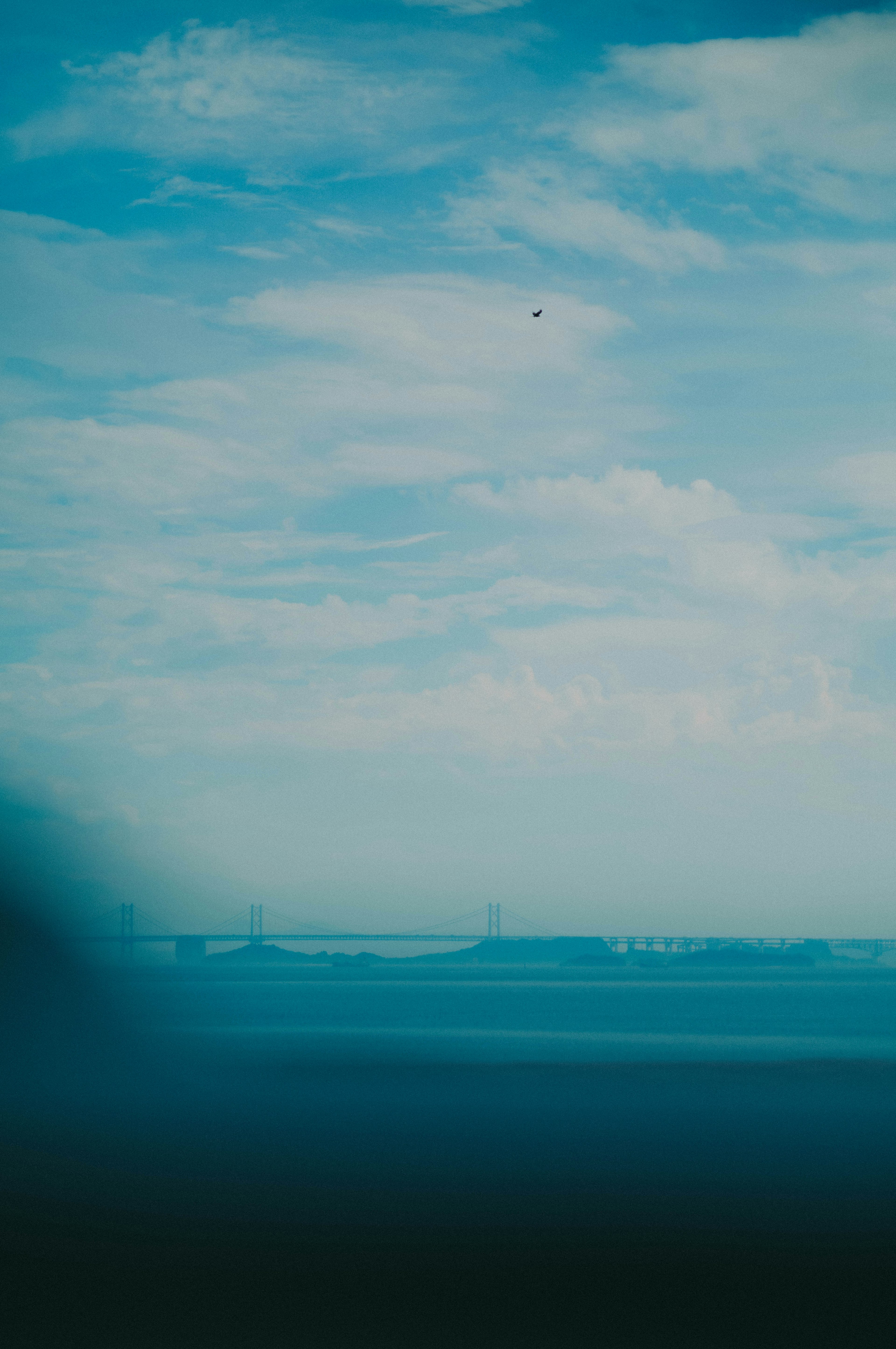 青い空と海の風景に薄い霧がかかっている