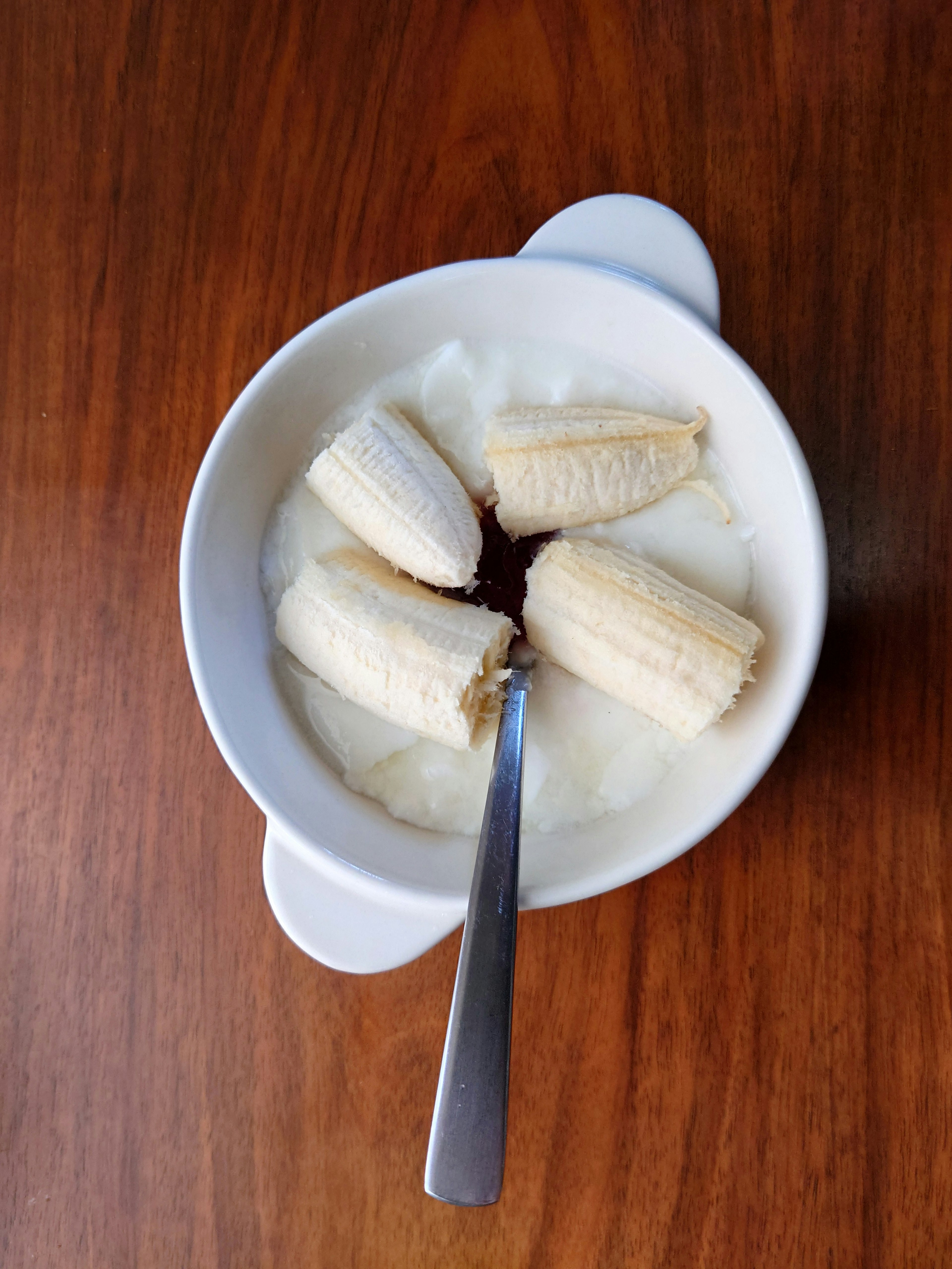 Yogur con rodajas de plátano en un tazón blanco