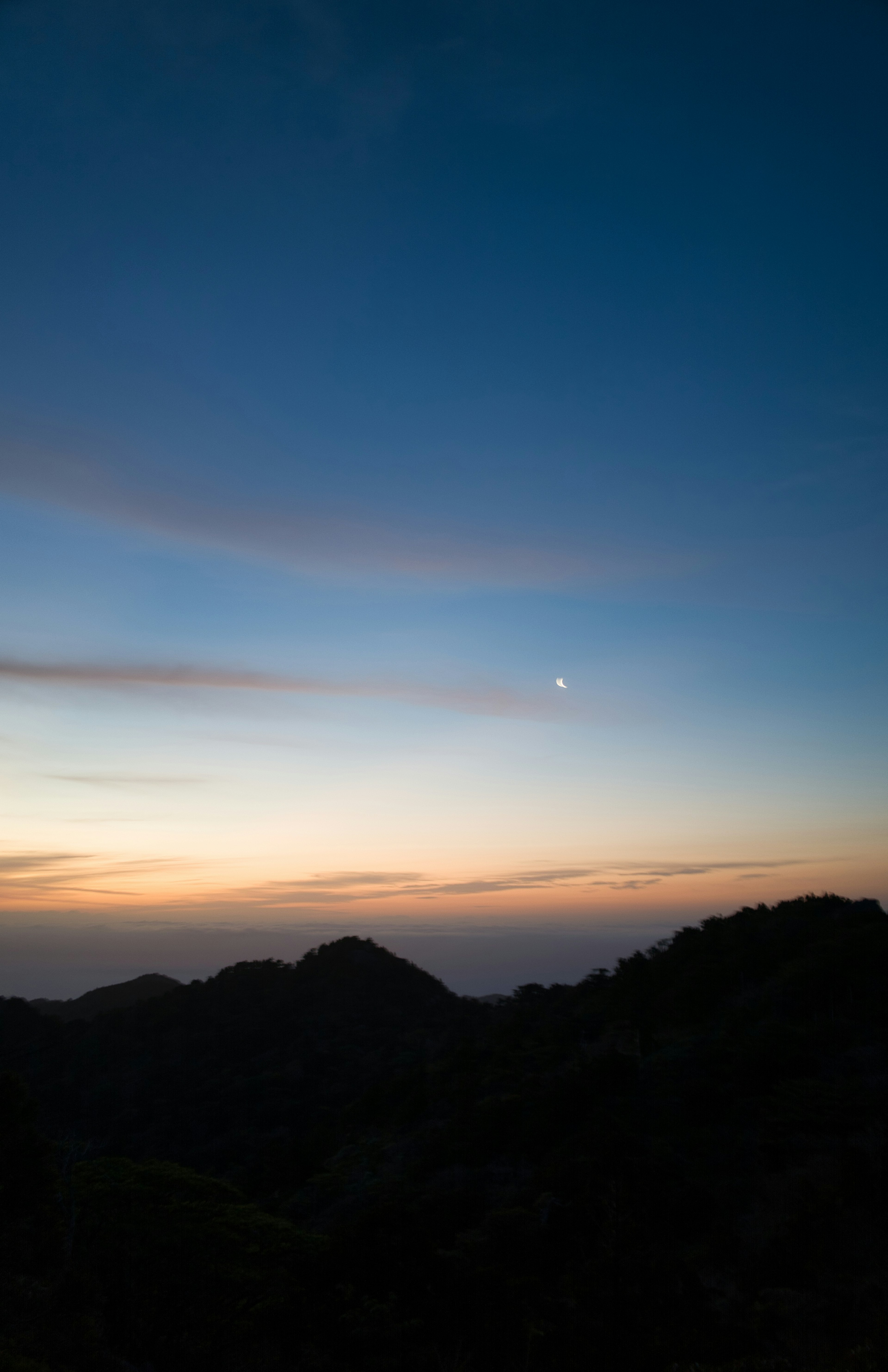 Eine Landschaft bei Sonnenuntergang mit blauem Himmel und Farbverläufen von Orange und Pink