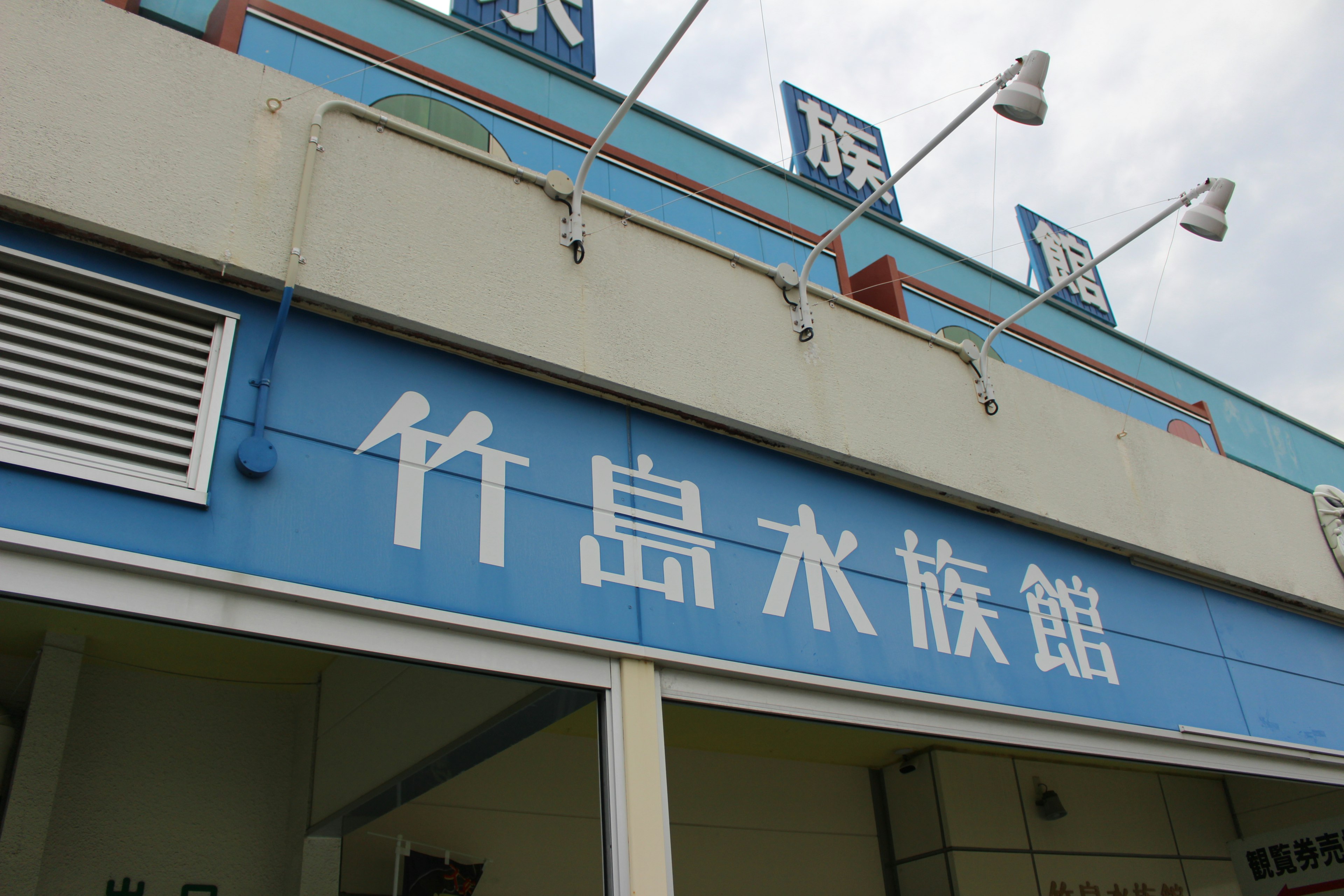 Vista exterior del acuario Takeshima con cartel azul