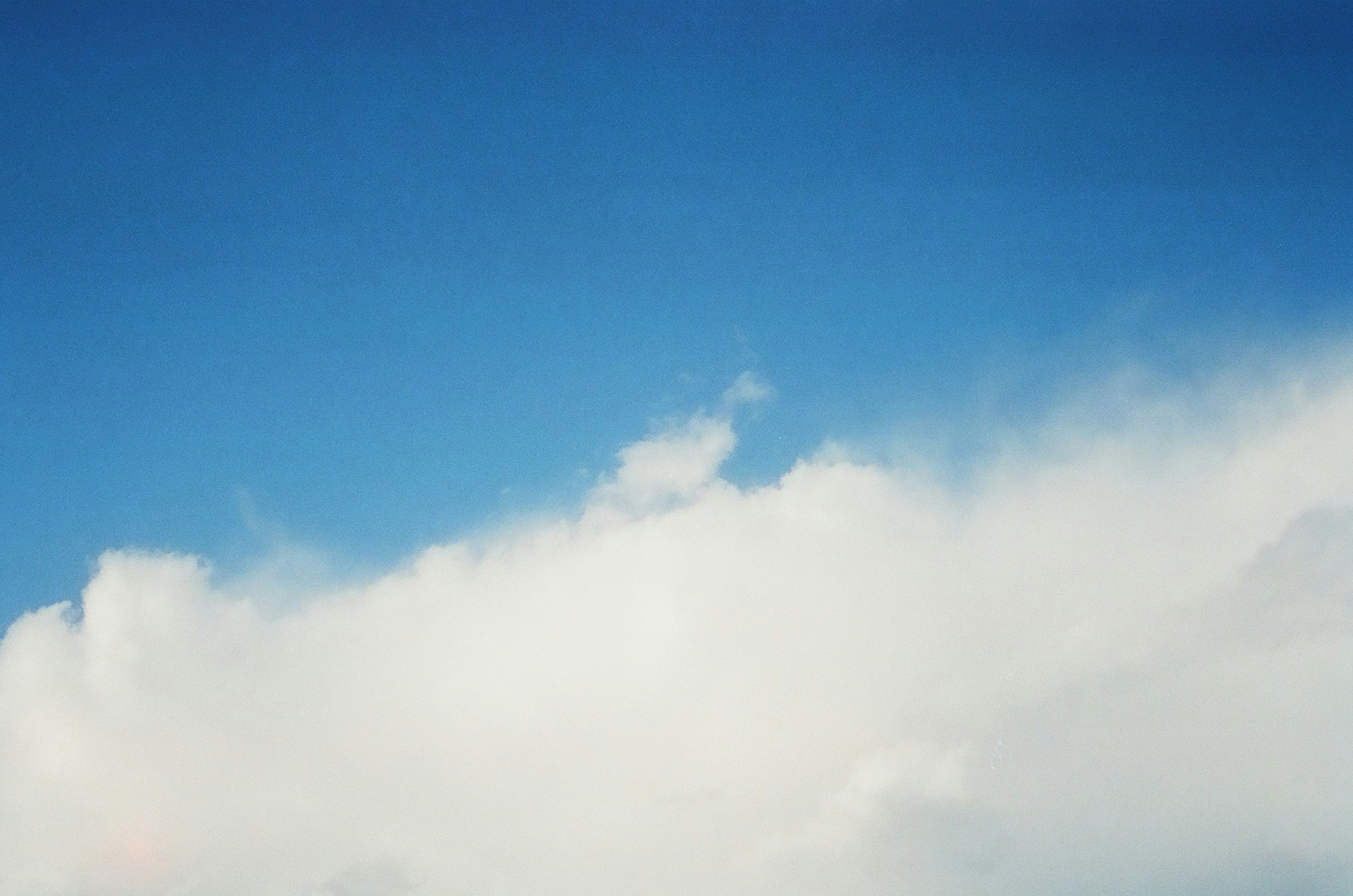 Partial view of blue sky with white clouds