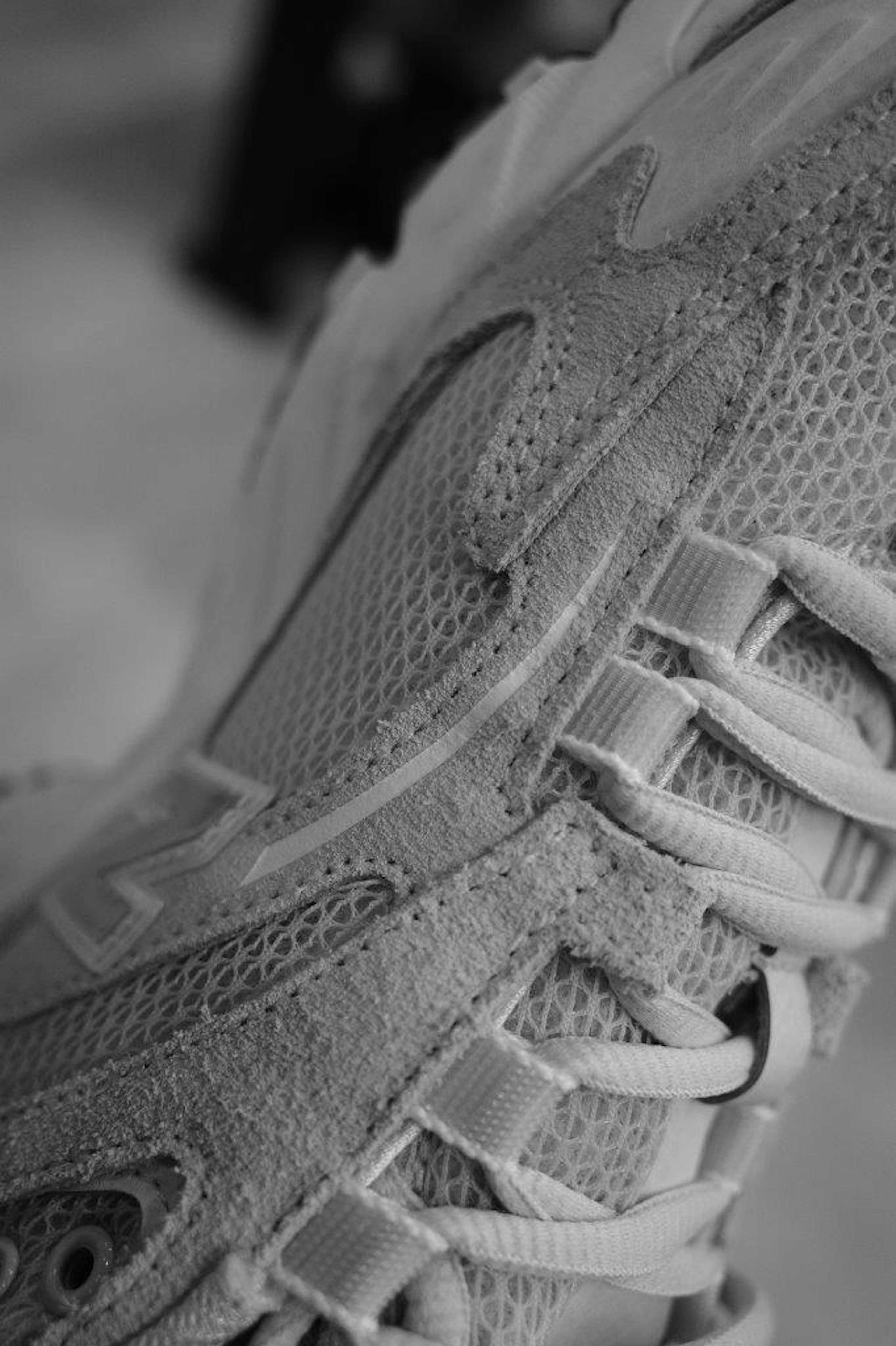 Photo en gros plan d'une sneaker en noir et blanc montrant des détails de maille et de lacets