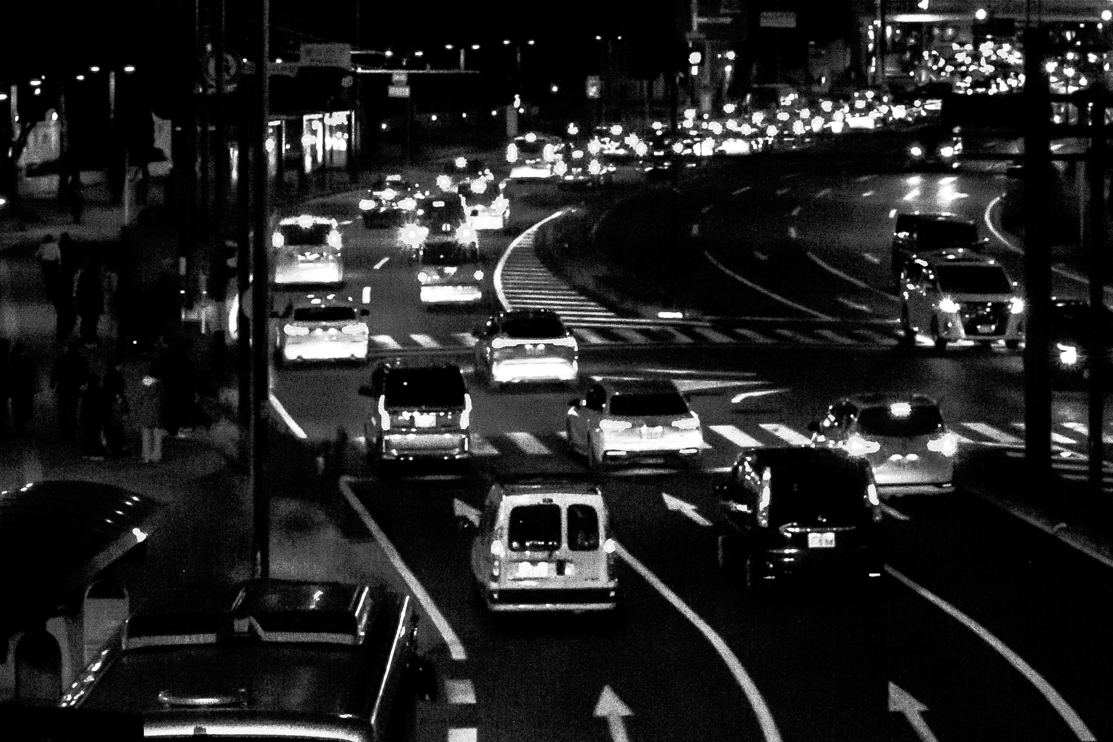 Schwarzweißfoto von nächtlichem Stadtverkehr