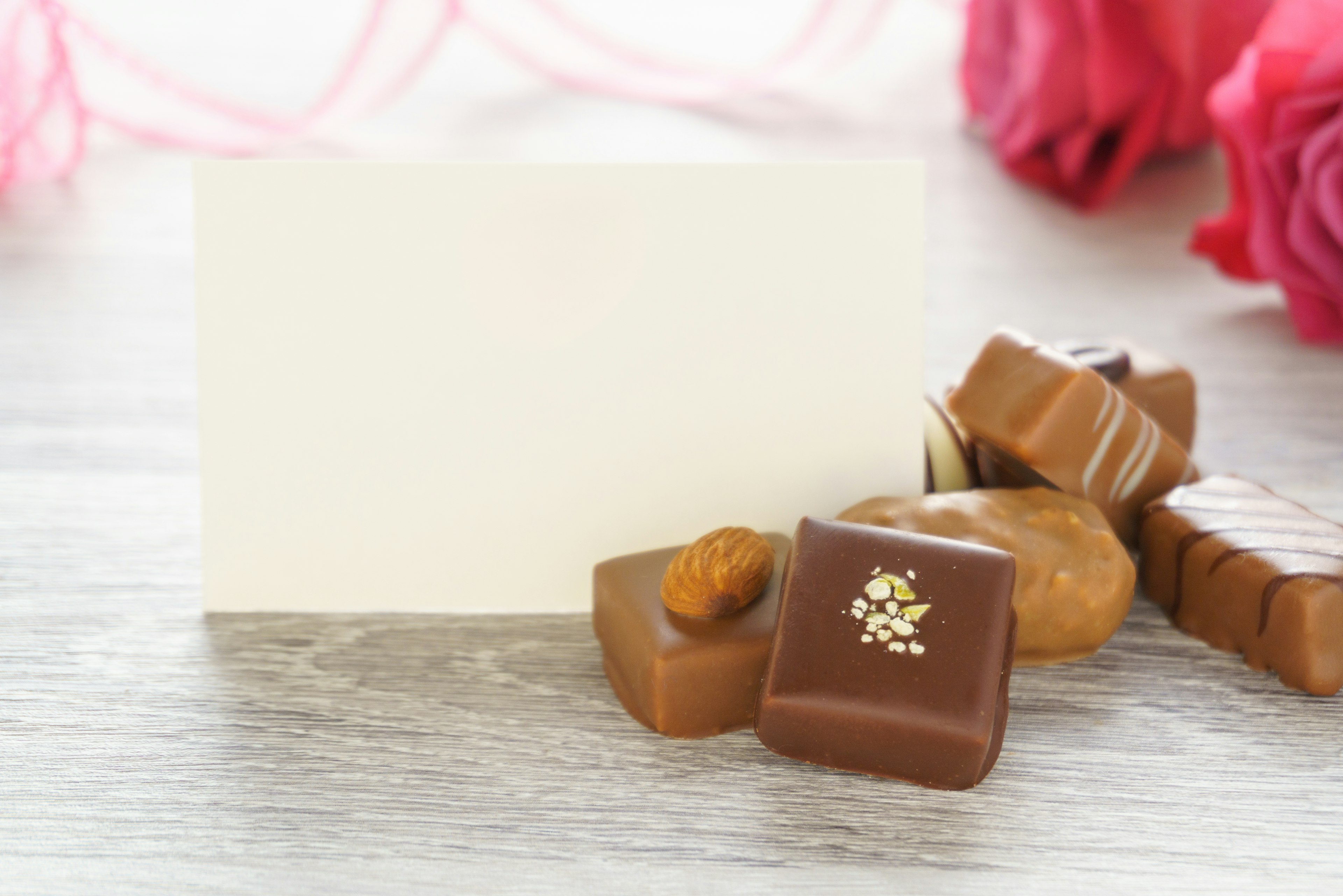 Image de chocolats assortis avec une carte blanche sur une table en bois