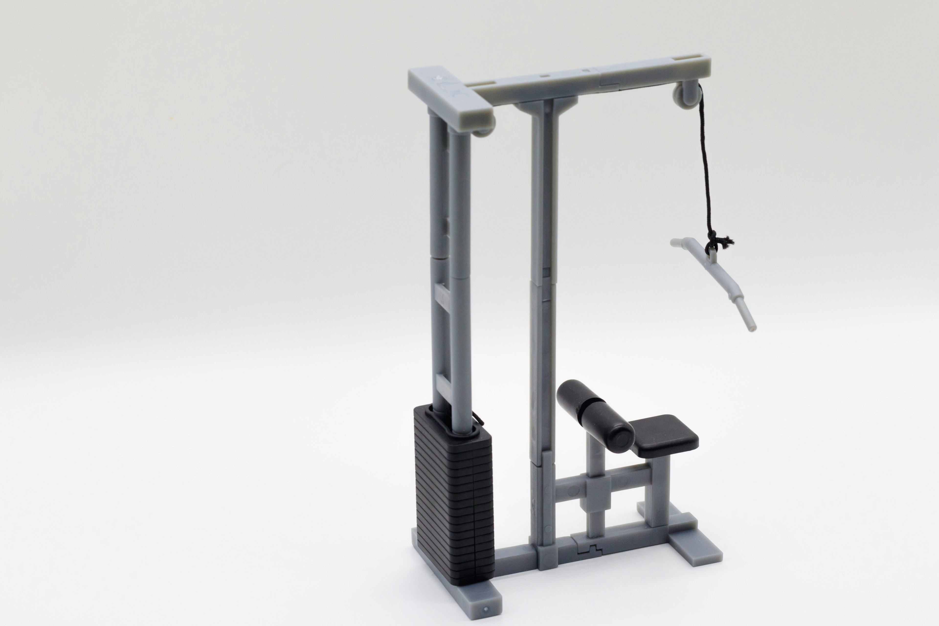 Photo of a gym lat pulldown machine featuring a simple gray design