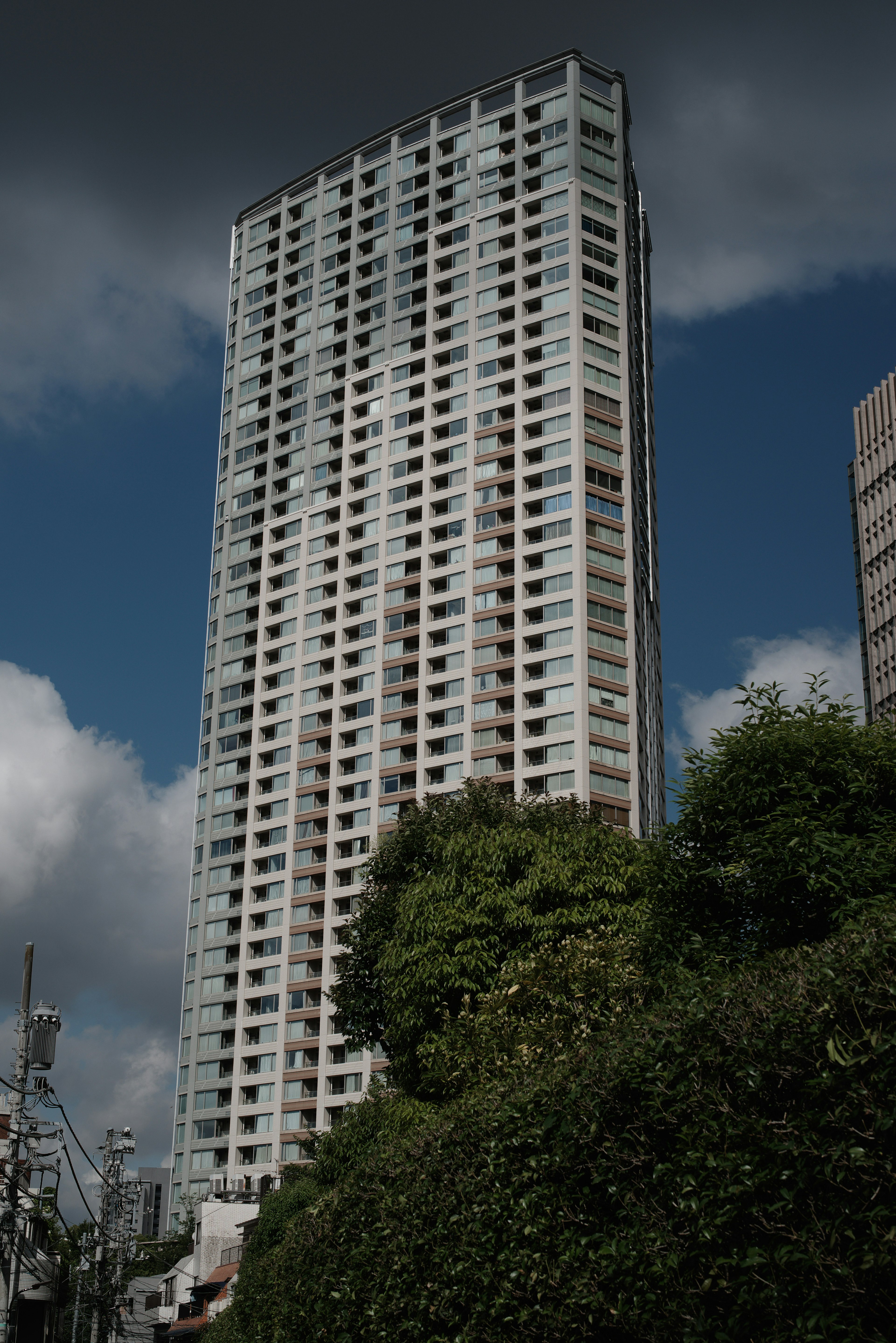 Alto edificio residenziale con vegetazione lussureggiante in primo piano