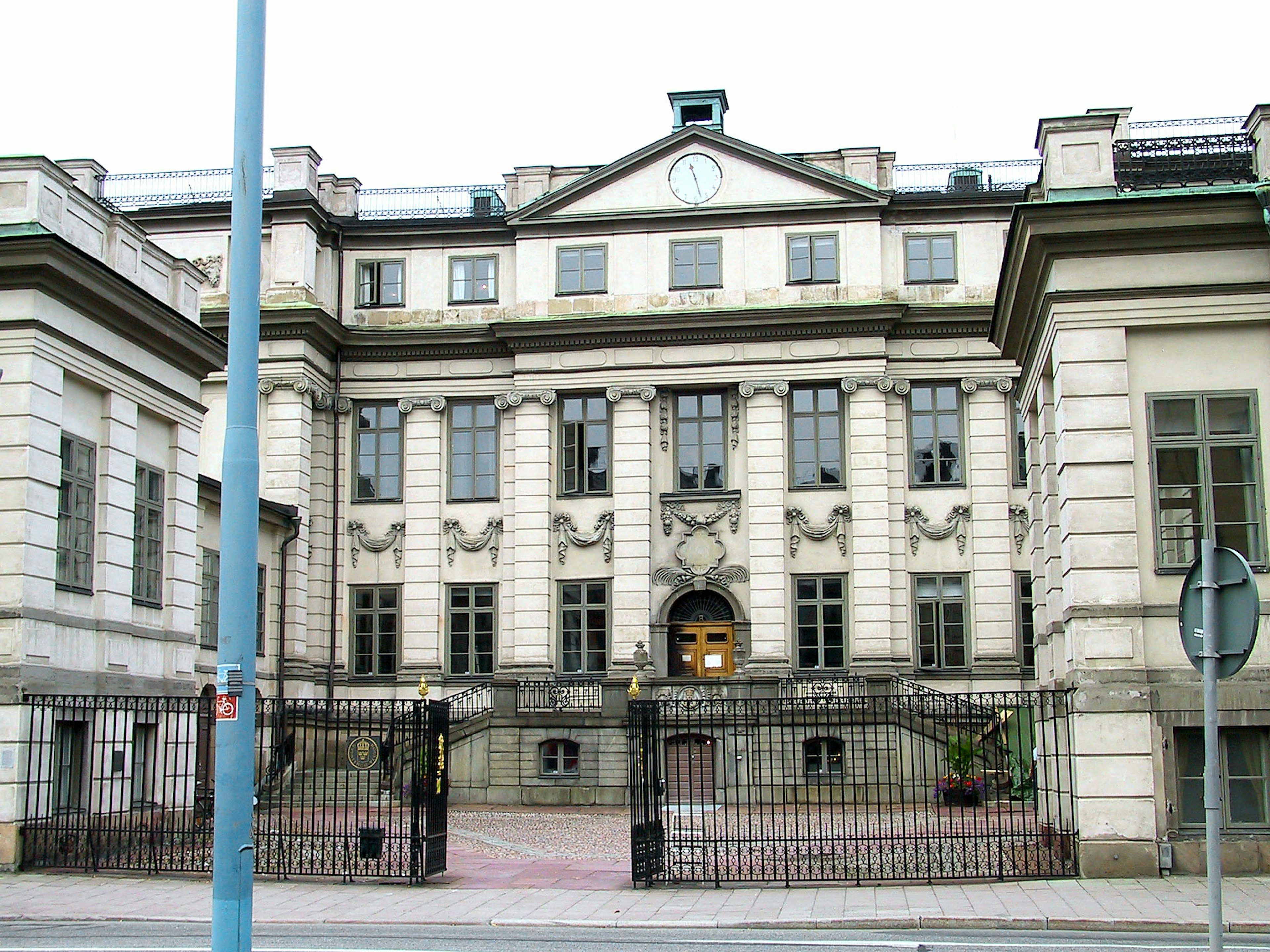 Extérieur d'un bâtiment historique avec une entrée clôturée