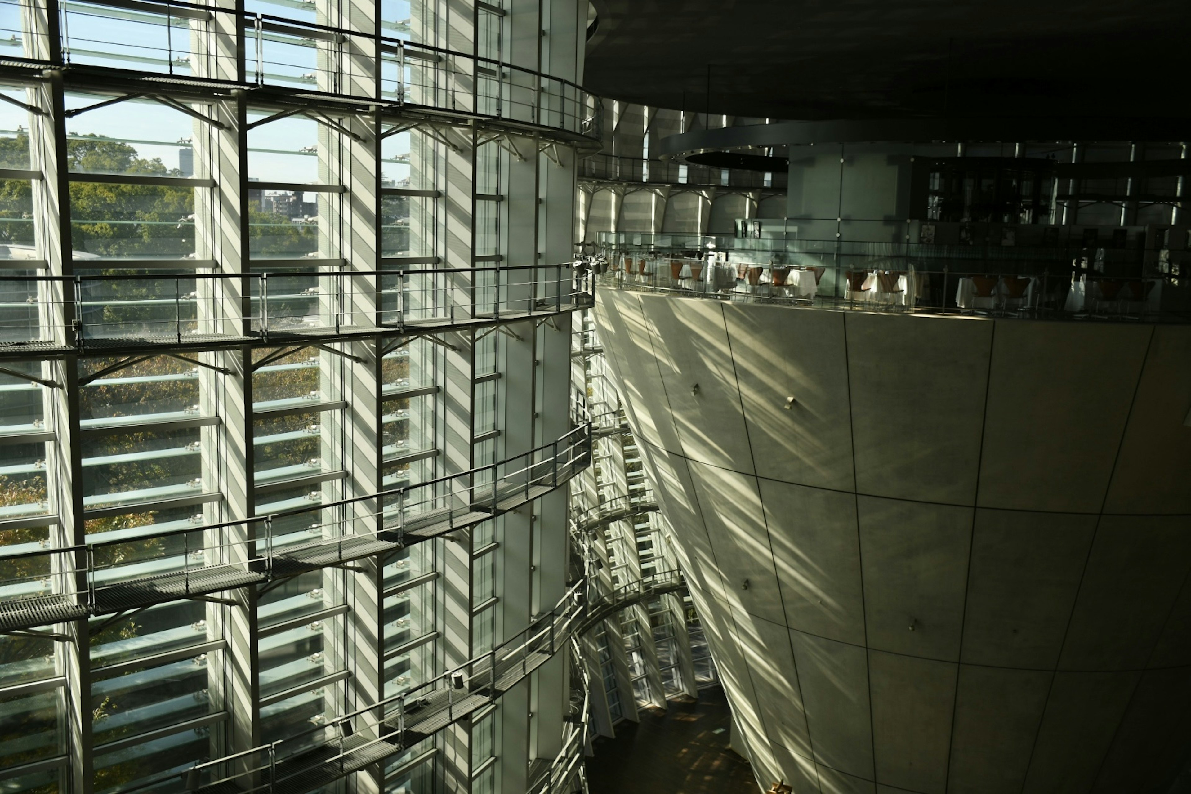 Interior of a modern building featuring transparent glass and concrete contrast with natural light streaming in