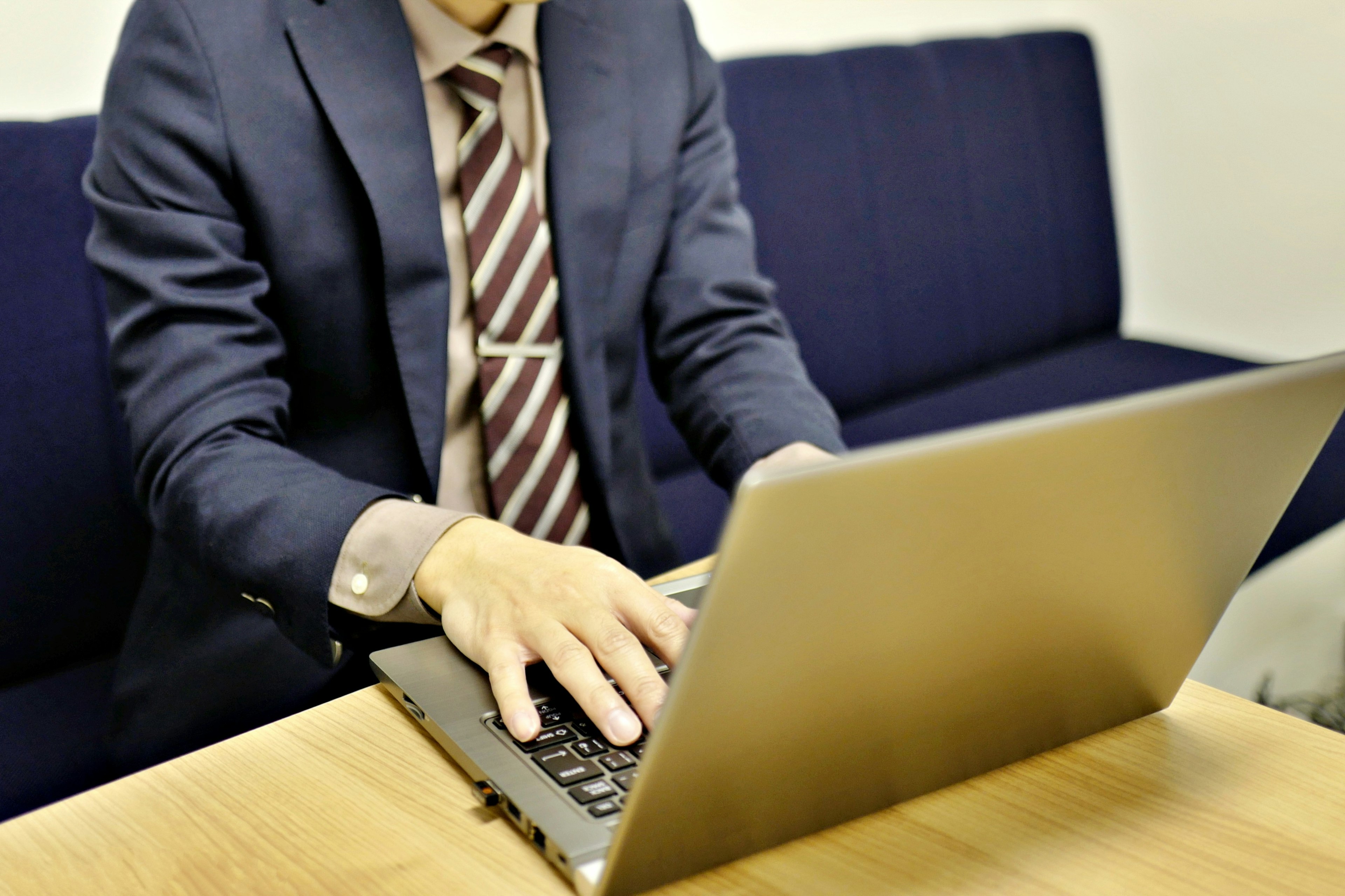 A man in a suit working on a laptop