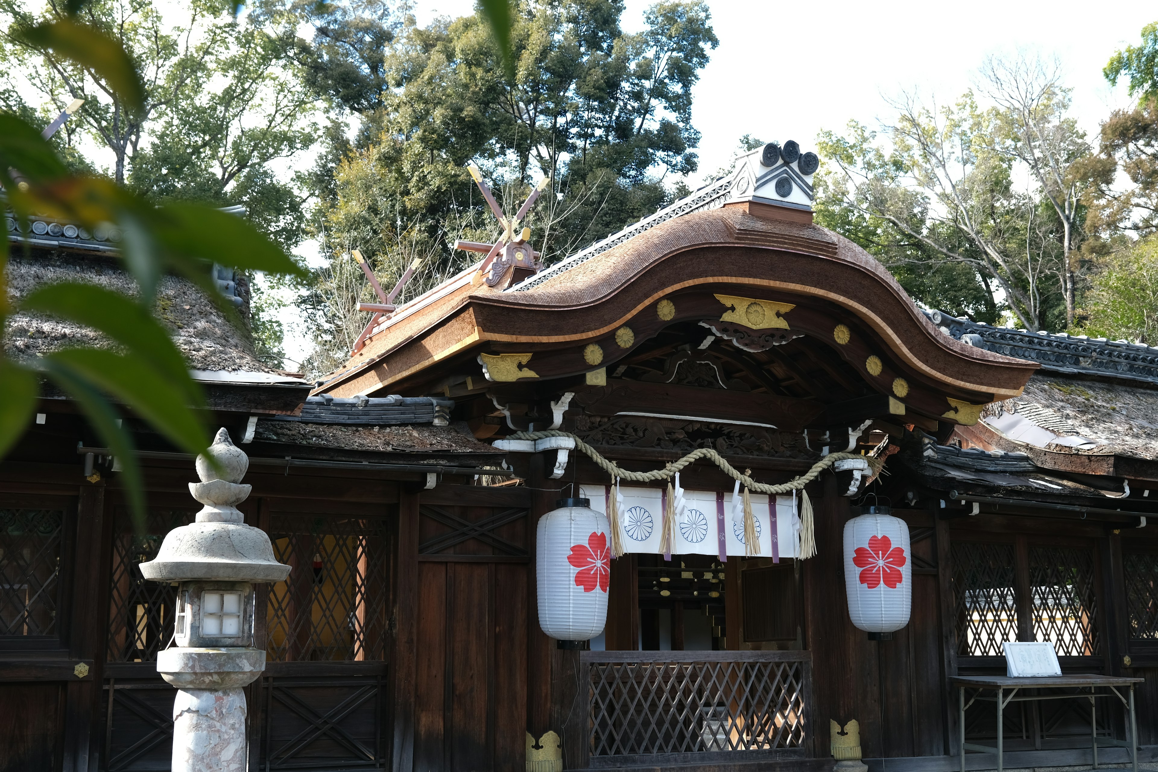 Beautiful shrine exterior with wooden roof and lanterns featuring traditional decorations