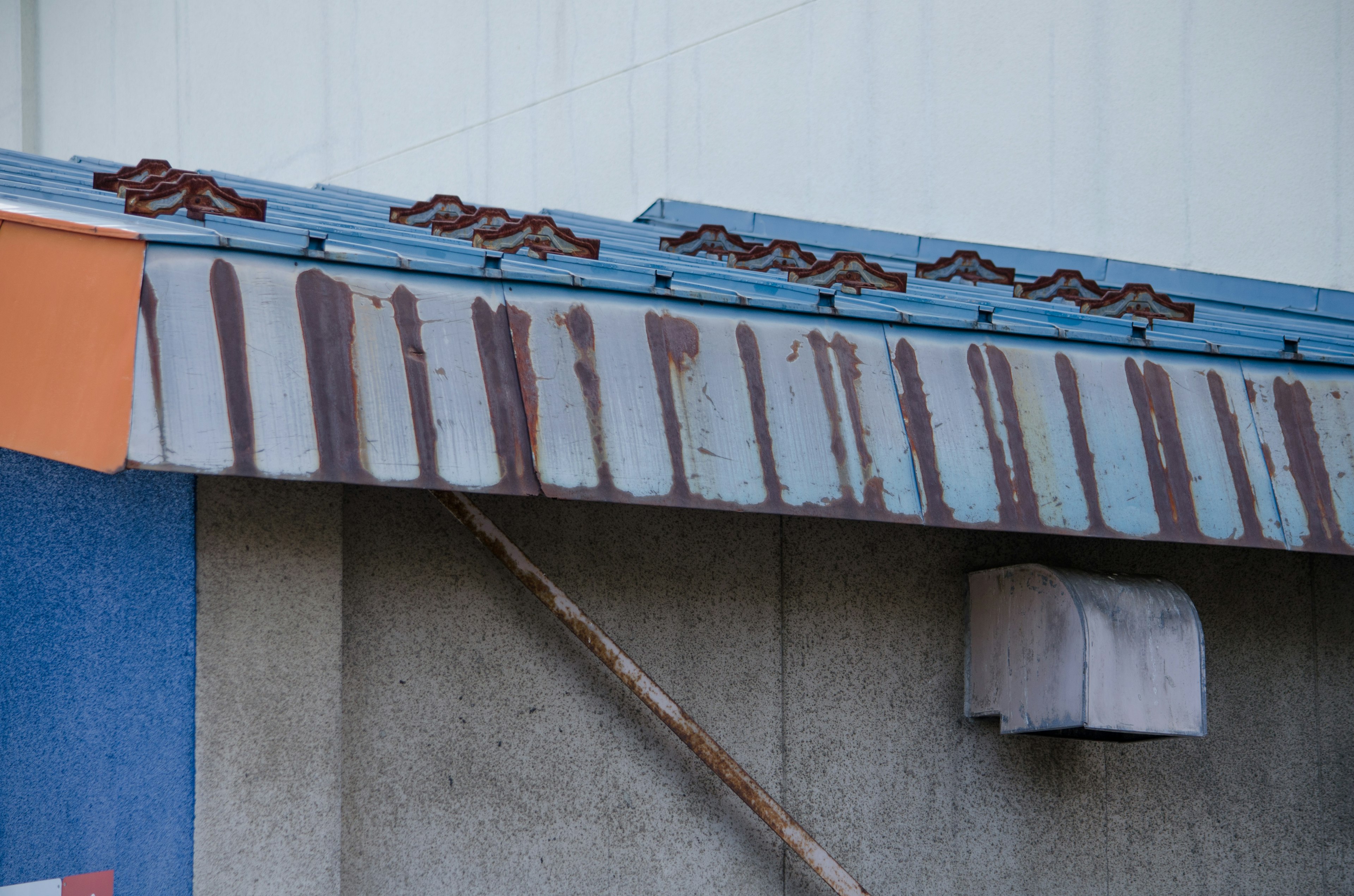 Toit en métal rouillé avec peinture bleue et détails usés