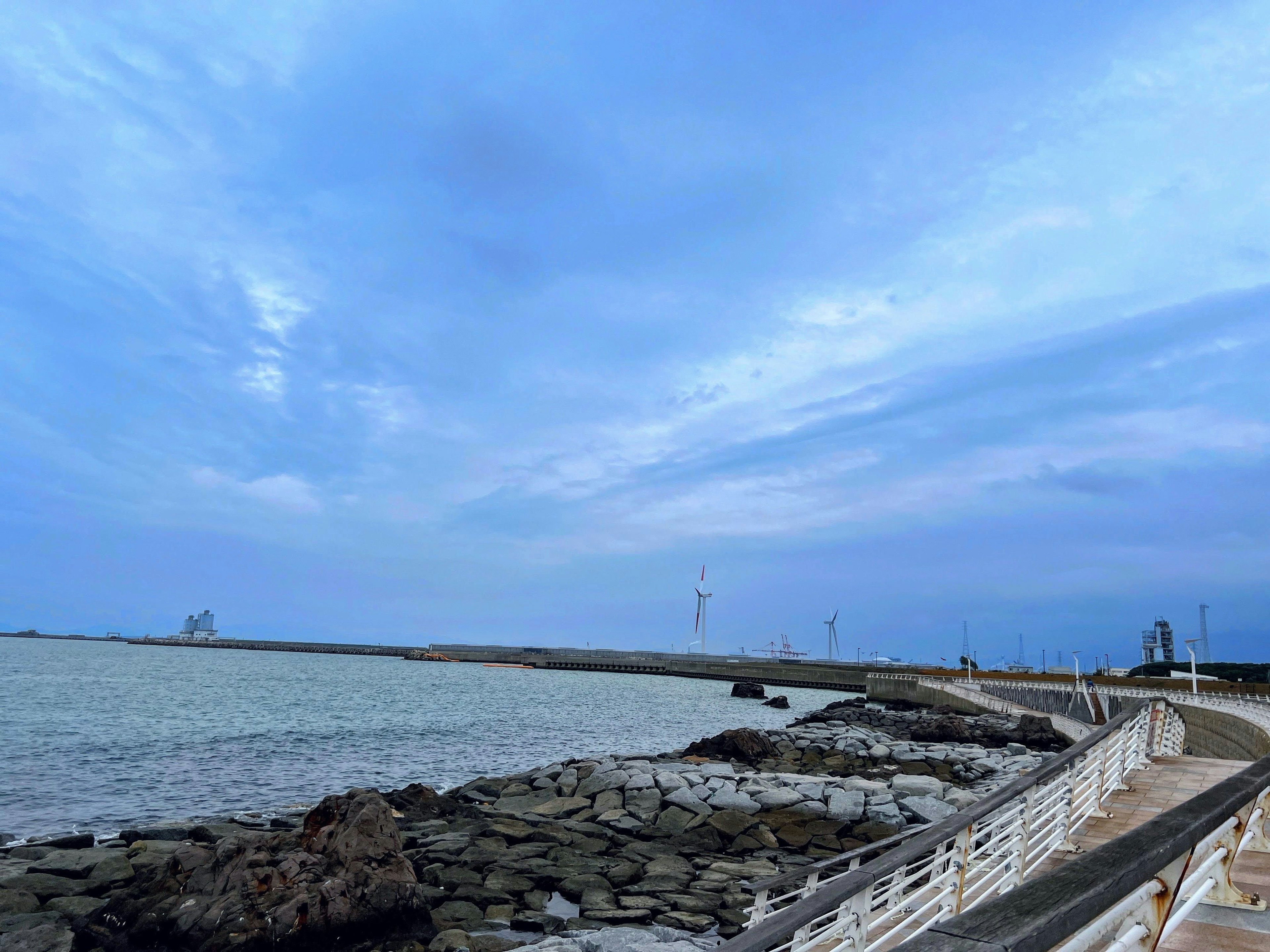 Coastal view featuring a rocky shoreline and blue sky