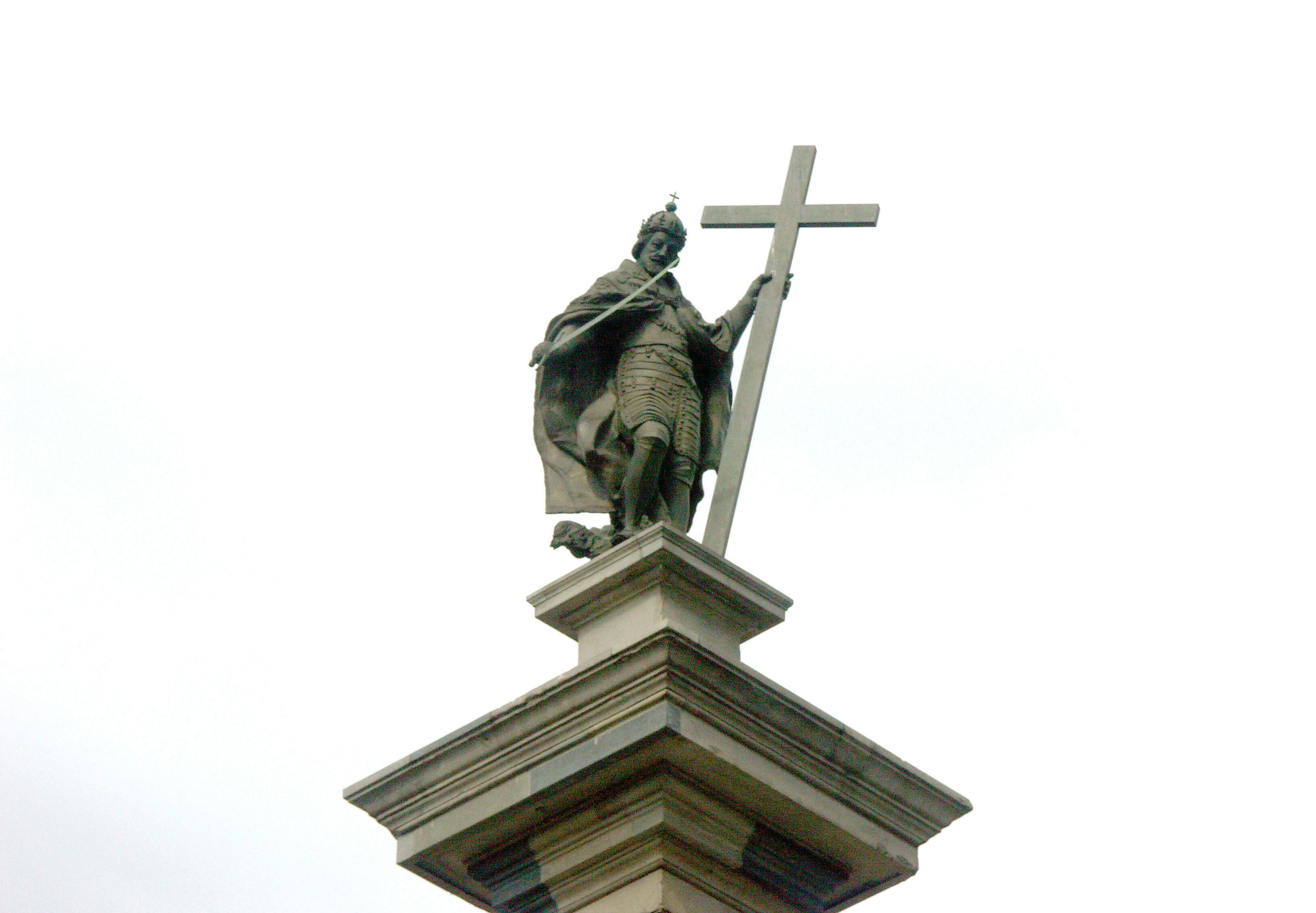 Estatua de un rey sosteniendo una cruz en la cima de un pilar