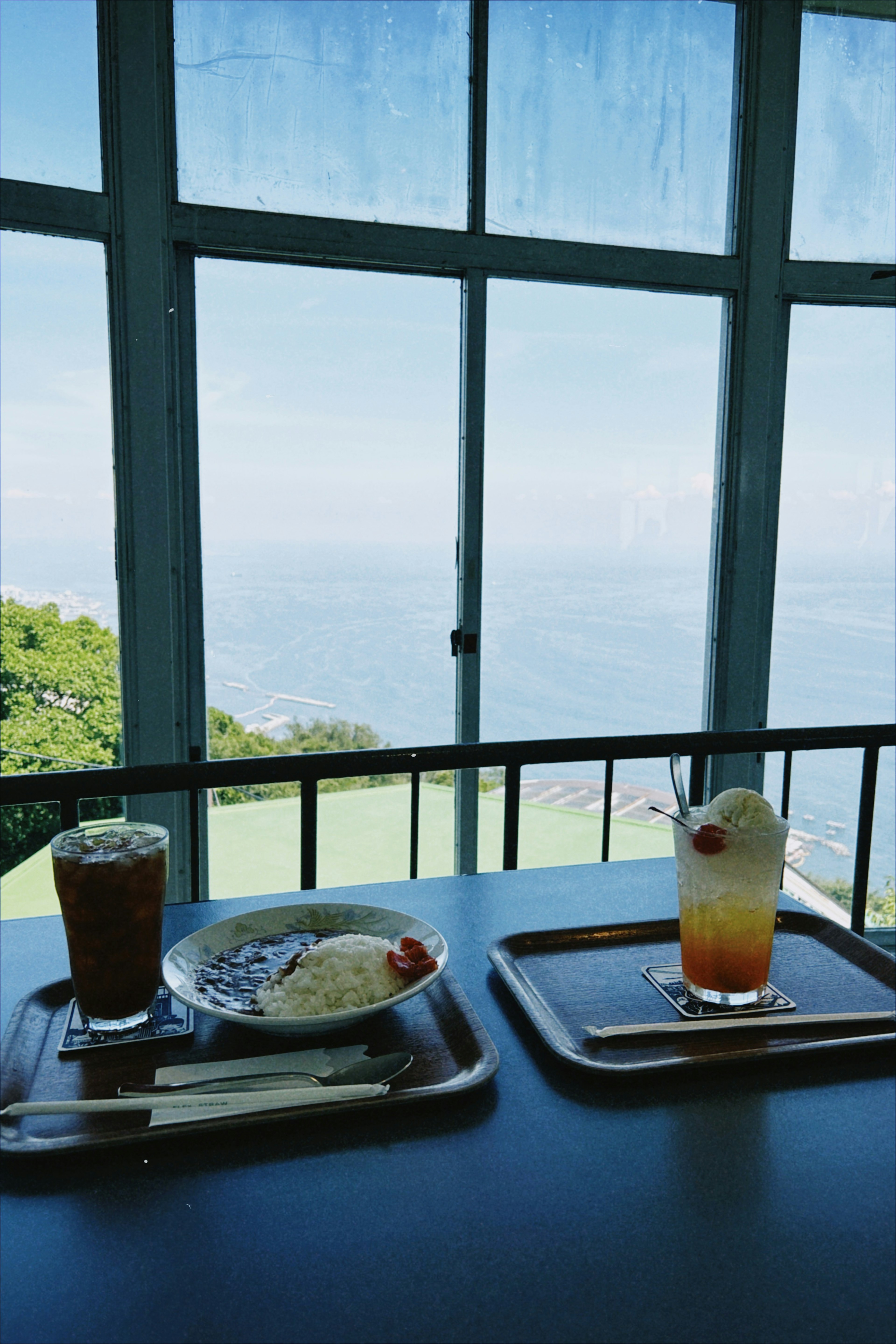 Scène de repas avec nourriture et boissons dans un café surplombant un paysage pittoresque