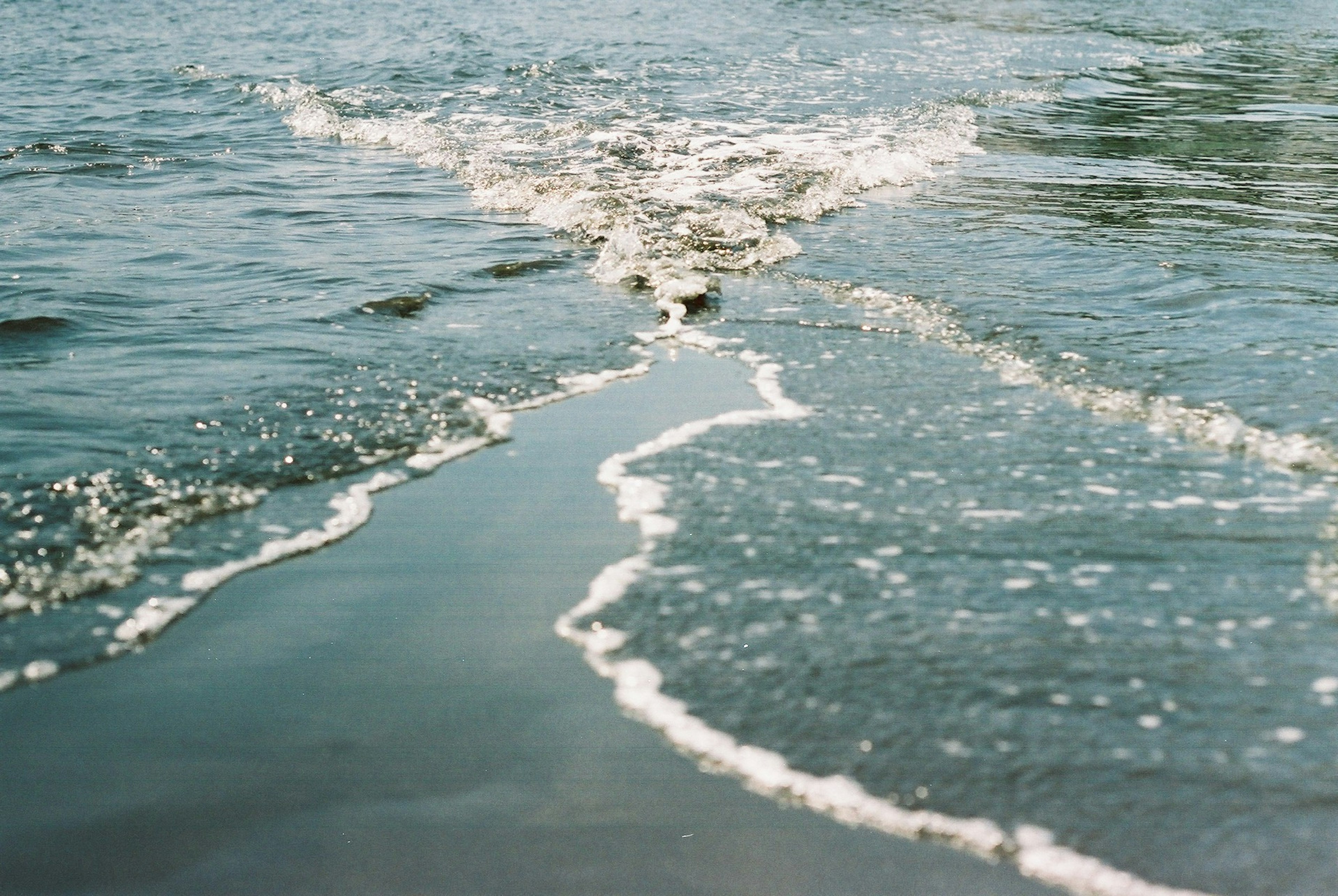 穏やかな海の波が砂浜に寄せている風景