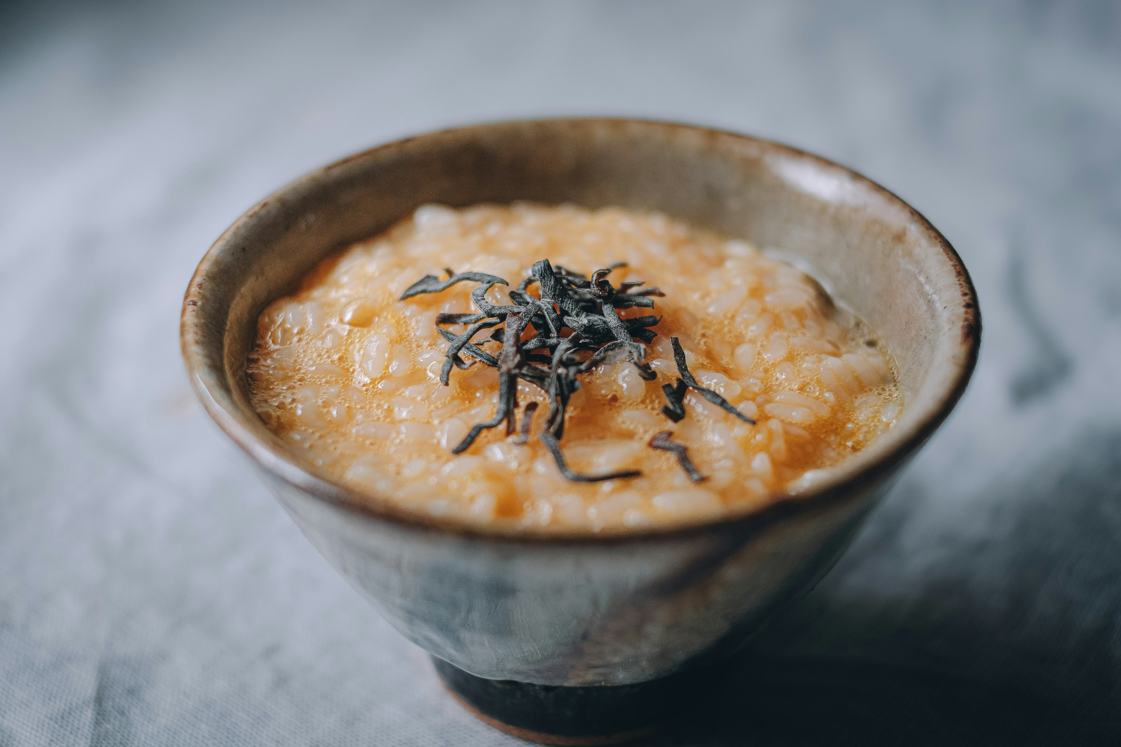 A bowl of congee topped with seaweed