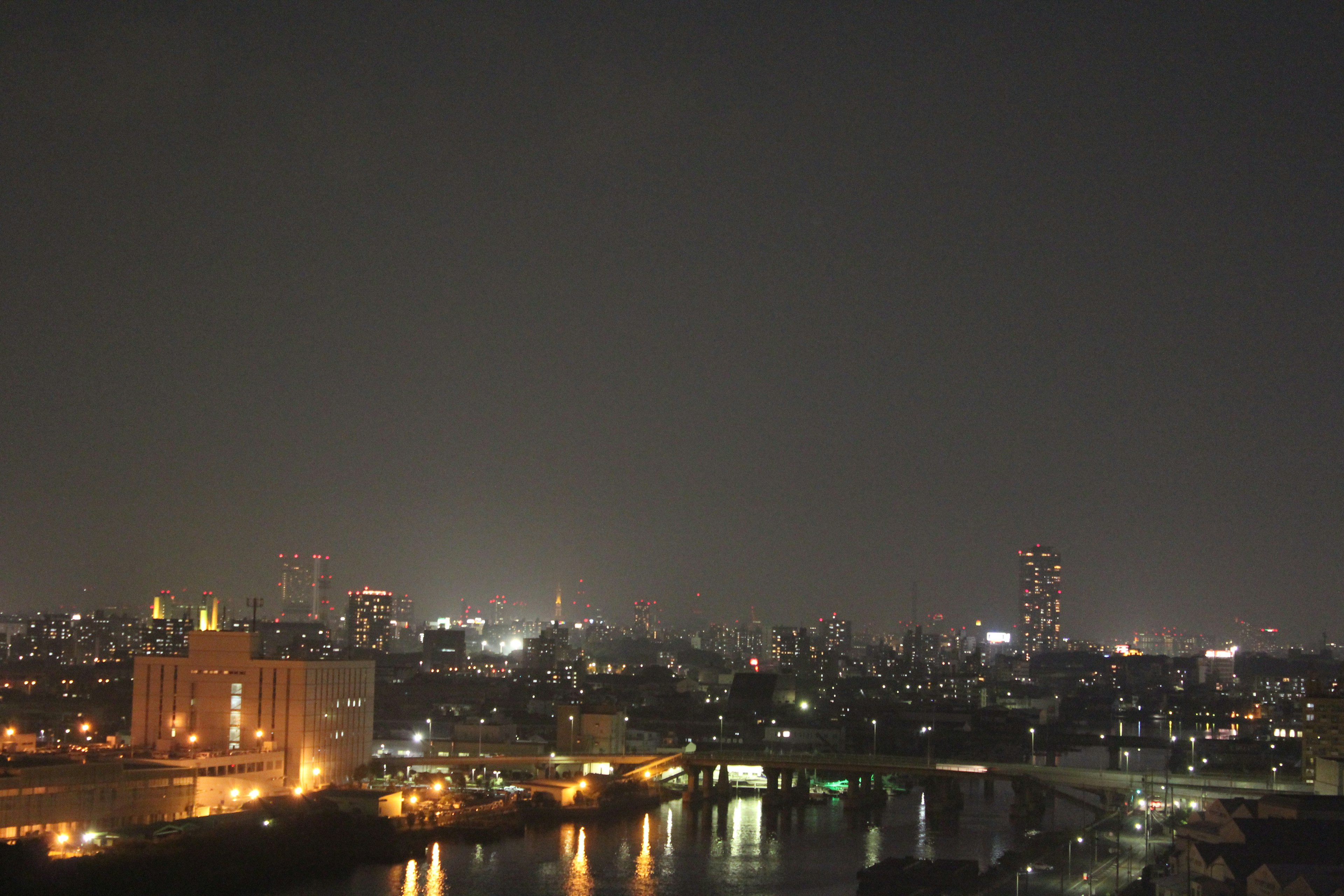 Paesaggio urbano notturno con edifici illuminati e fiume