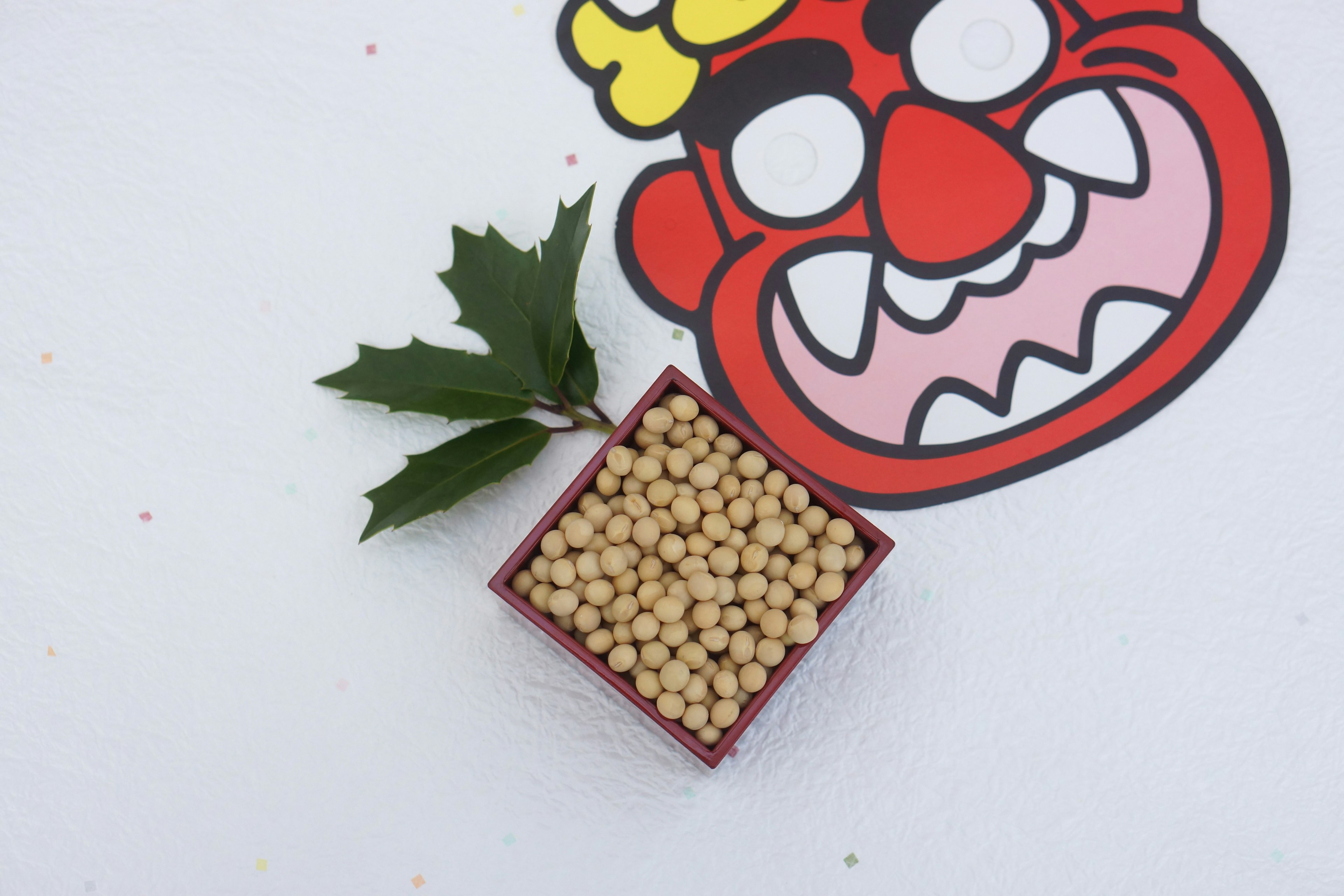 Image featuring a red demon face and a box filled with beans