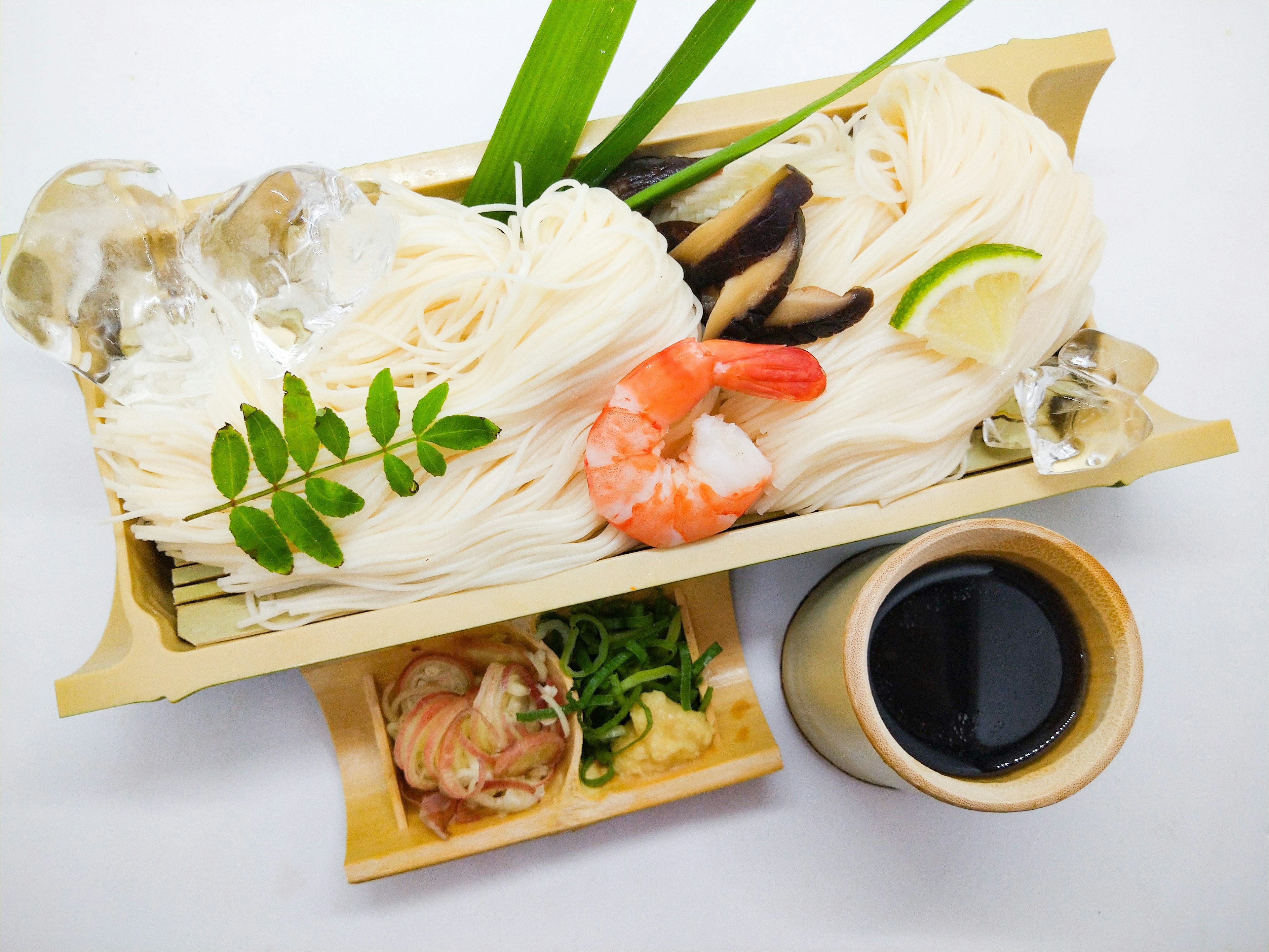 Un plato con camarones frescos y fideos somen decorados con vegetación