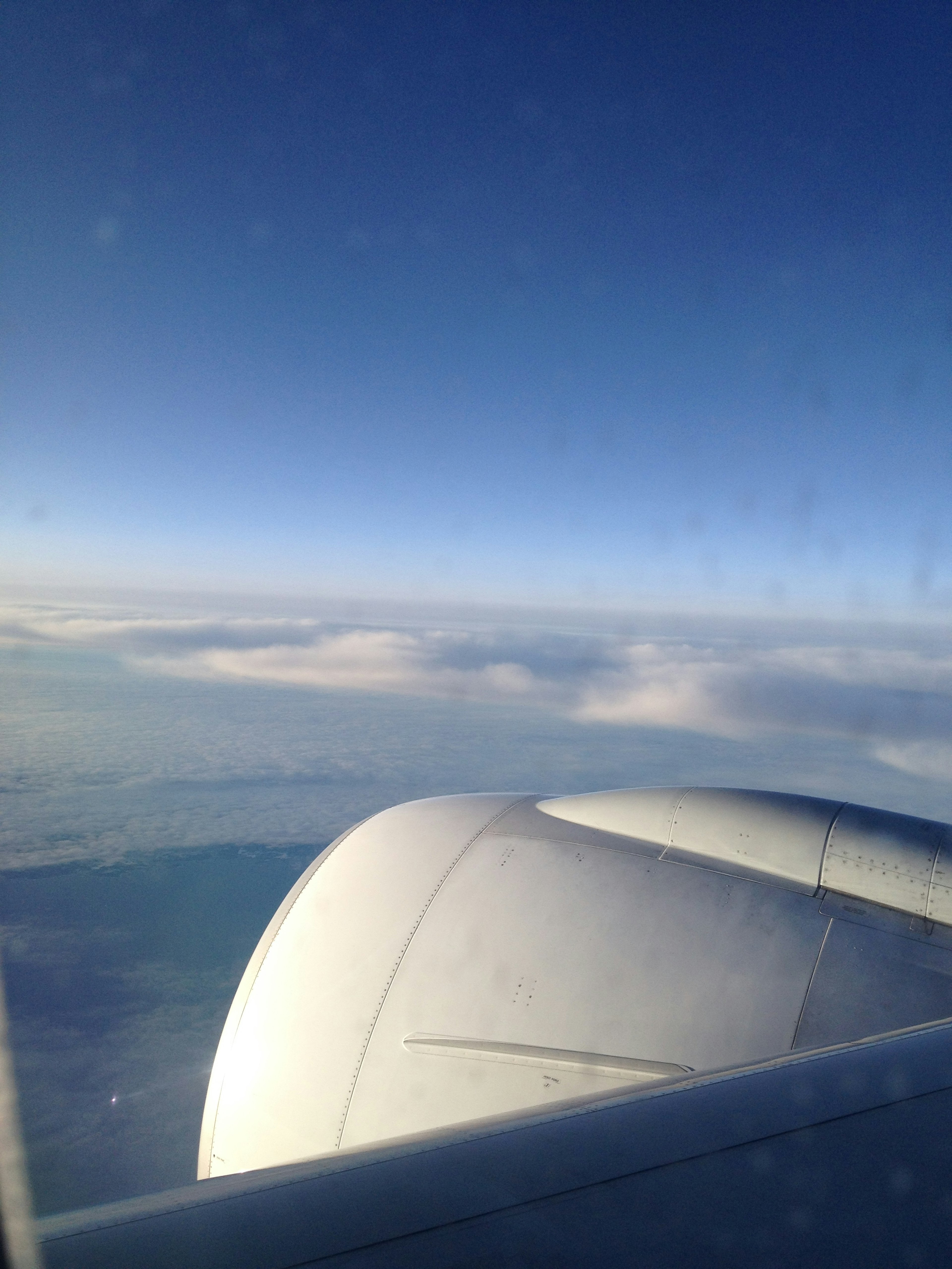 Blick auf den blauen Himmel und Wolken aus dem Flugzeugfenster