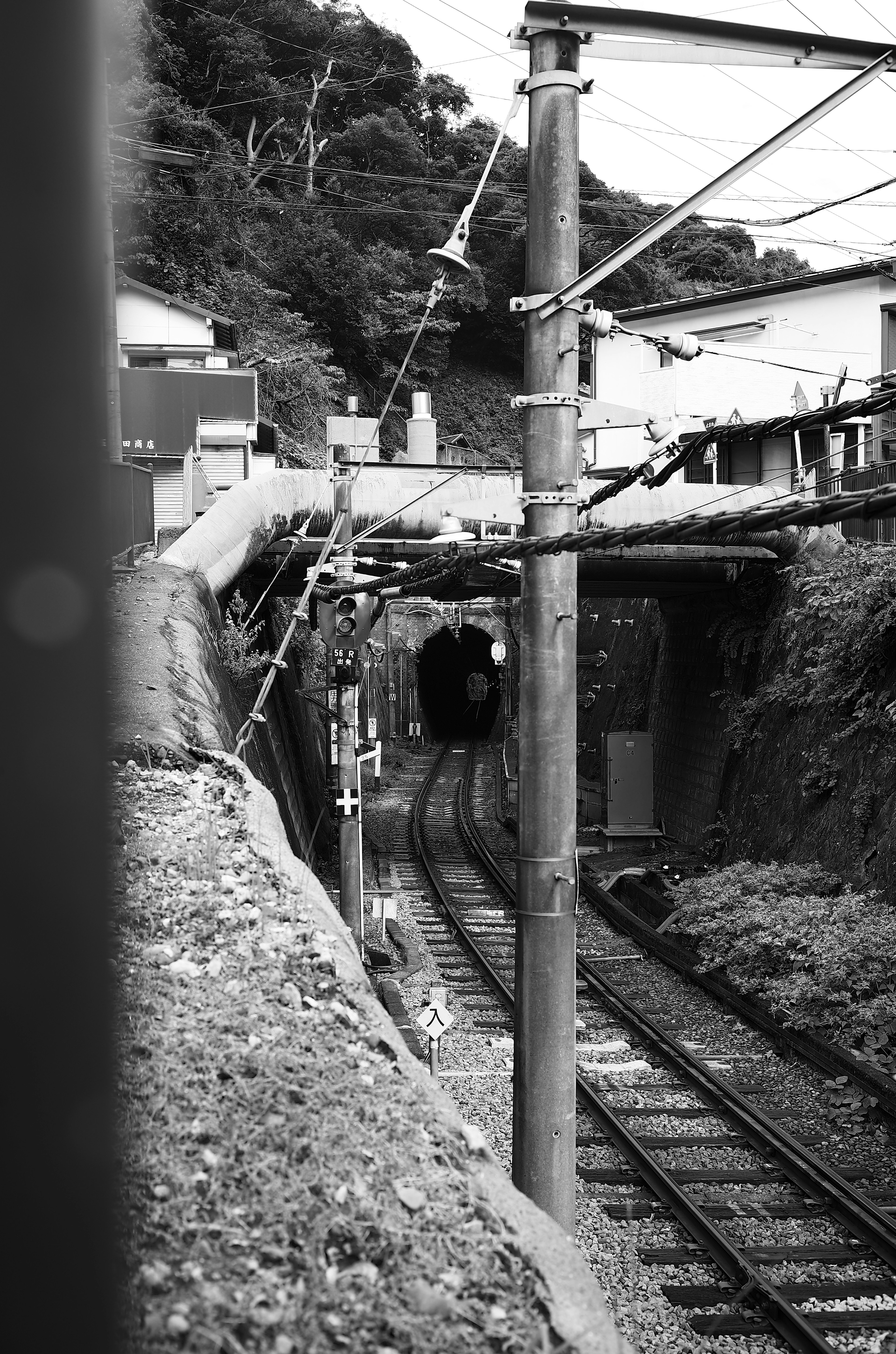 Schwarzweiß-Eisenbahnszene, die in einen Tunnel führt