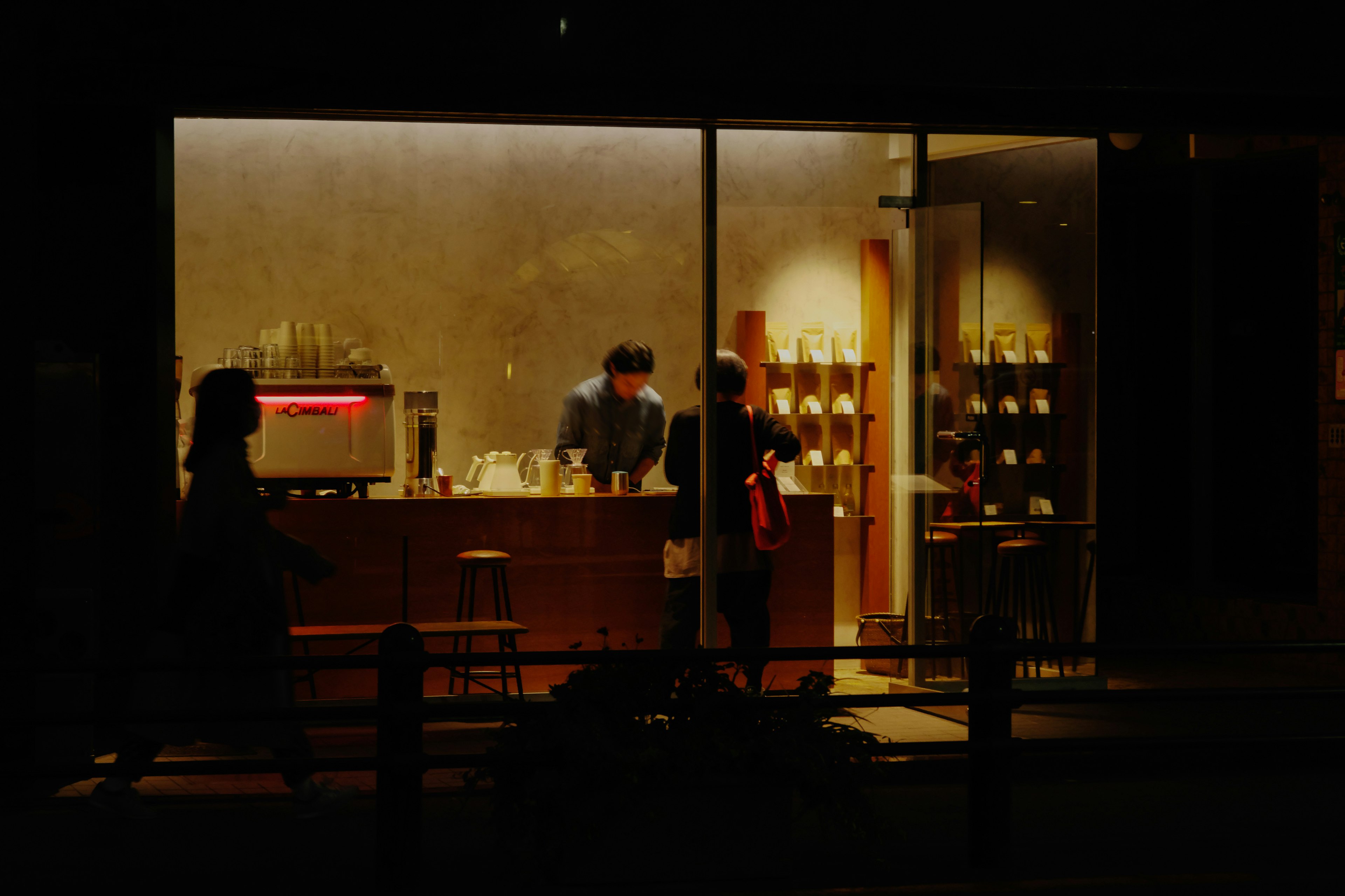 Interior de un café por la noche con un barista y un cliente