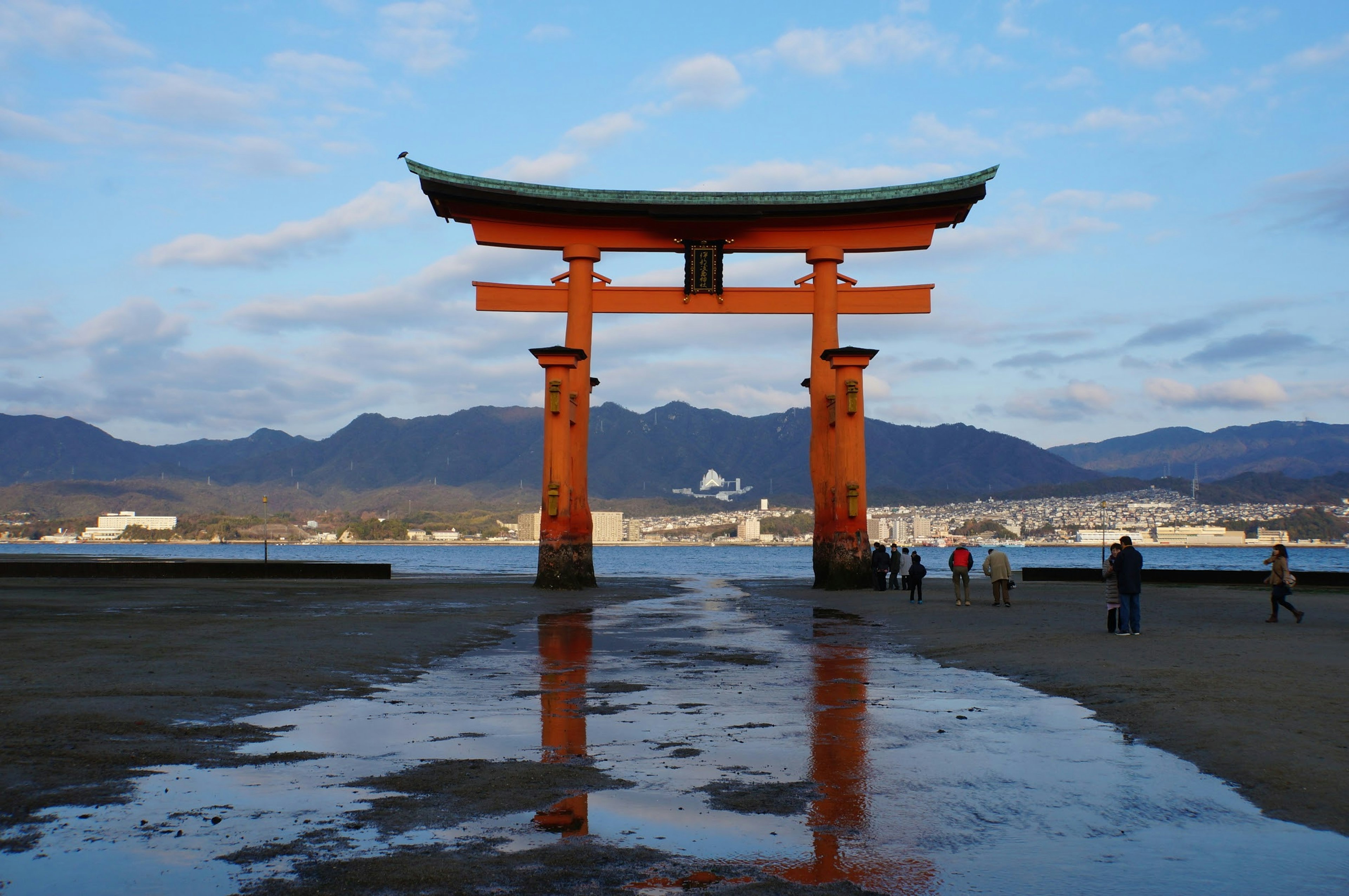 Schöne Aussicht auf ein Torii am Meer mit Bergen im Hintergrund