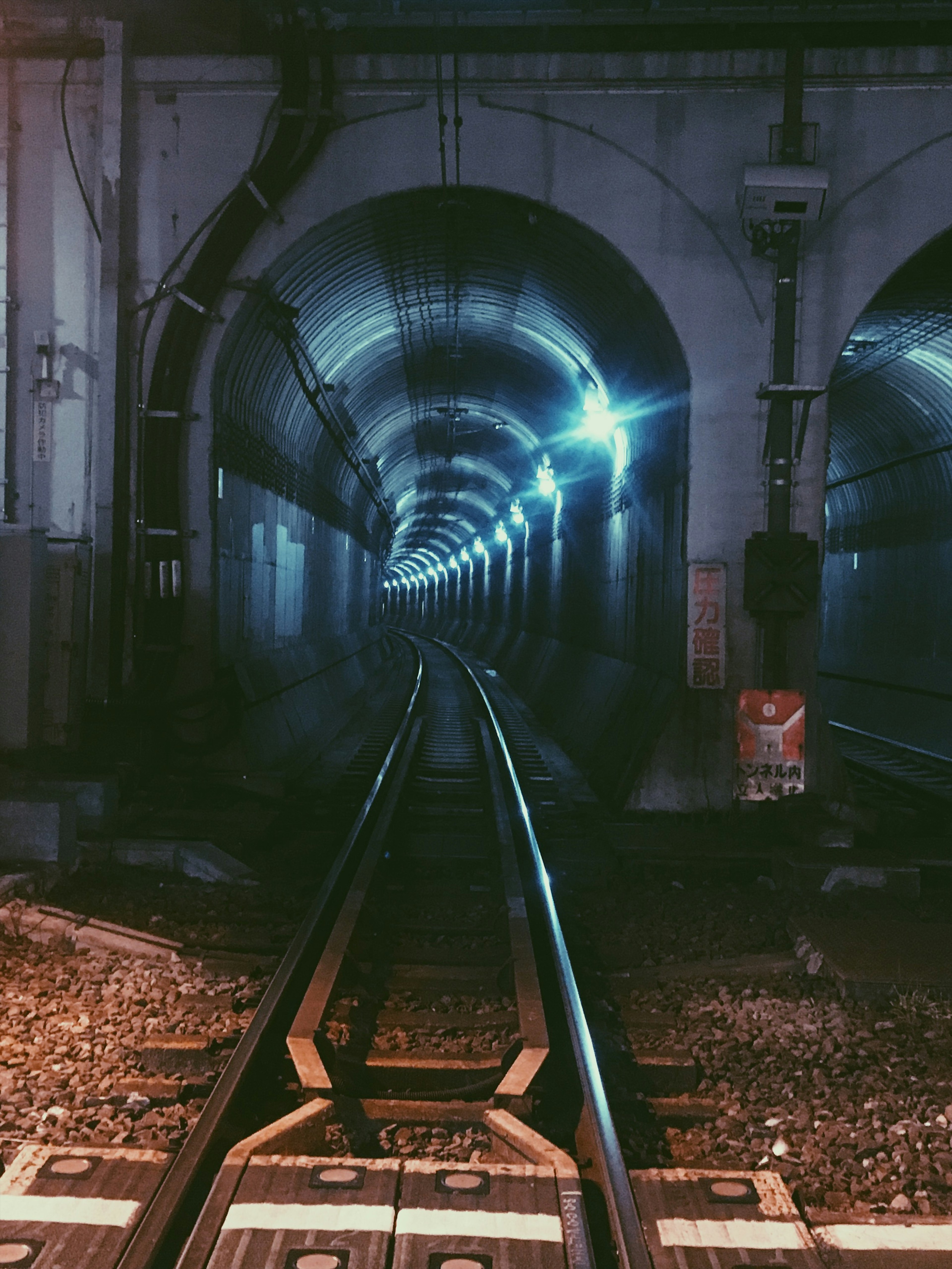 Vue des rails de chemin de fer à l'intérieur d'un tunnel avec un éclairage bleu