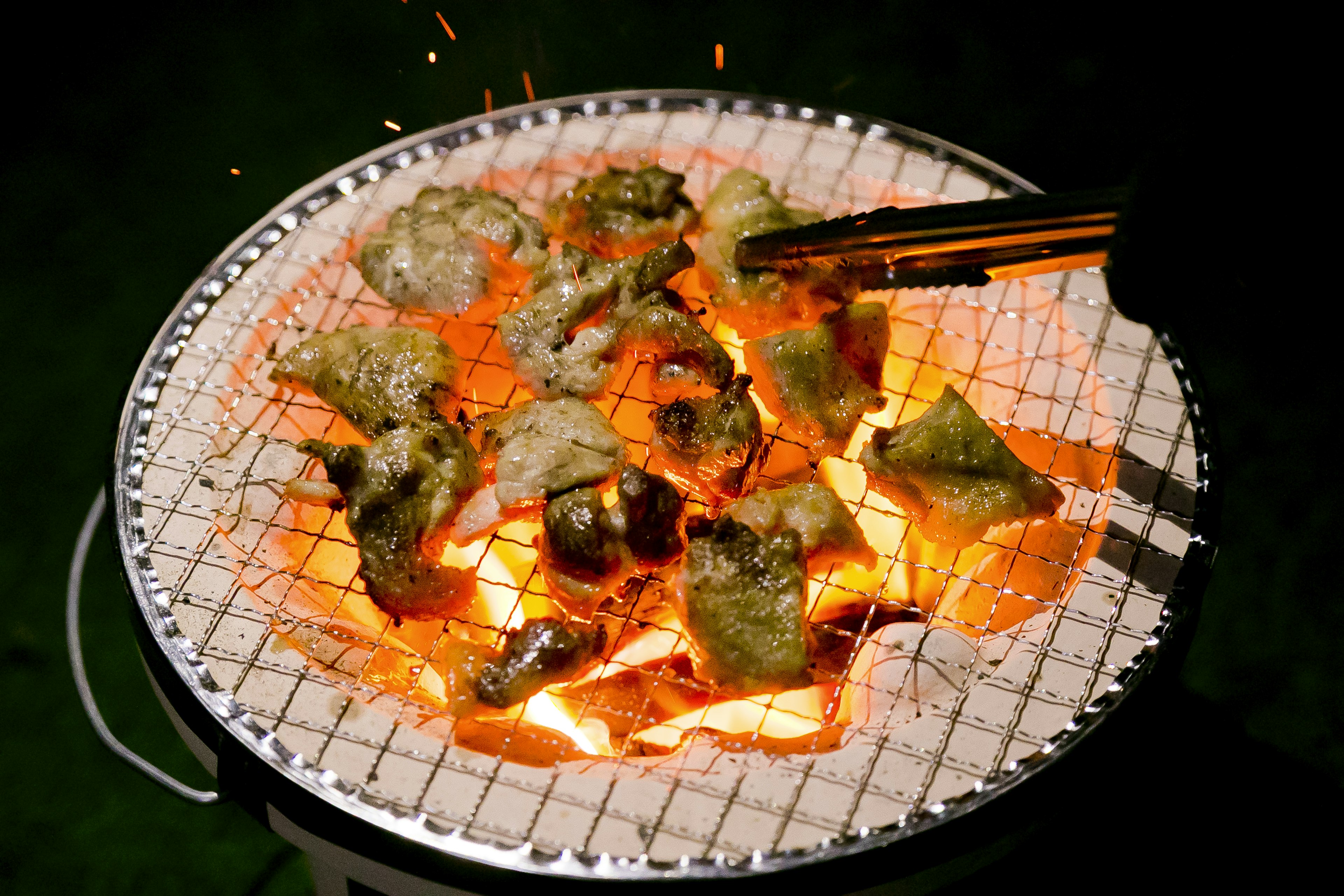 Grilled food on a charcoal grill with sparks