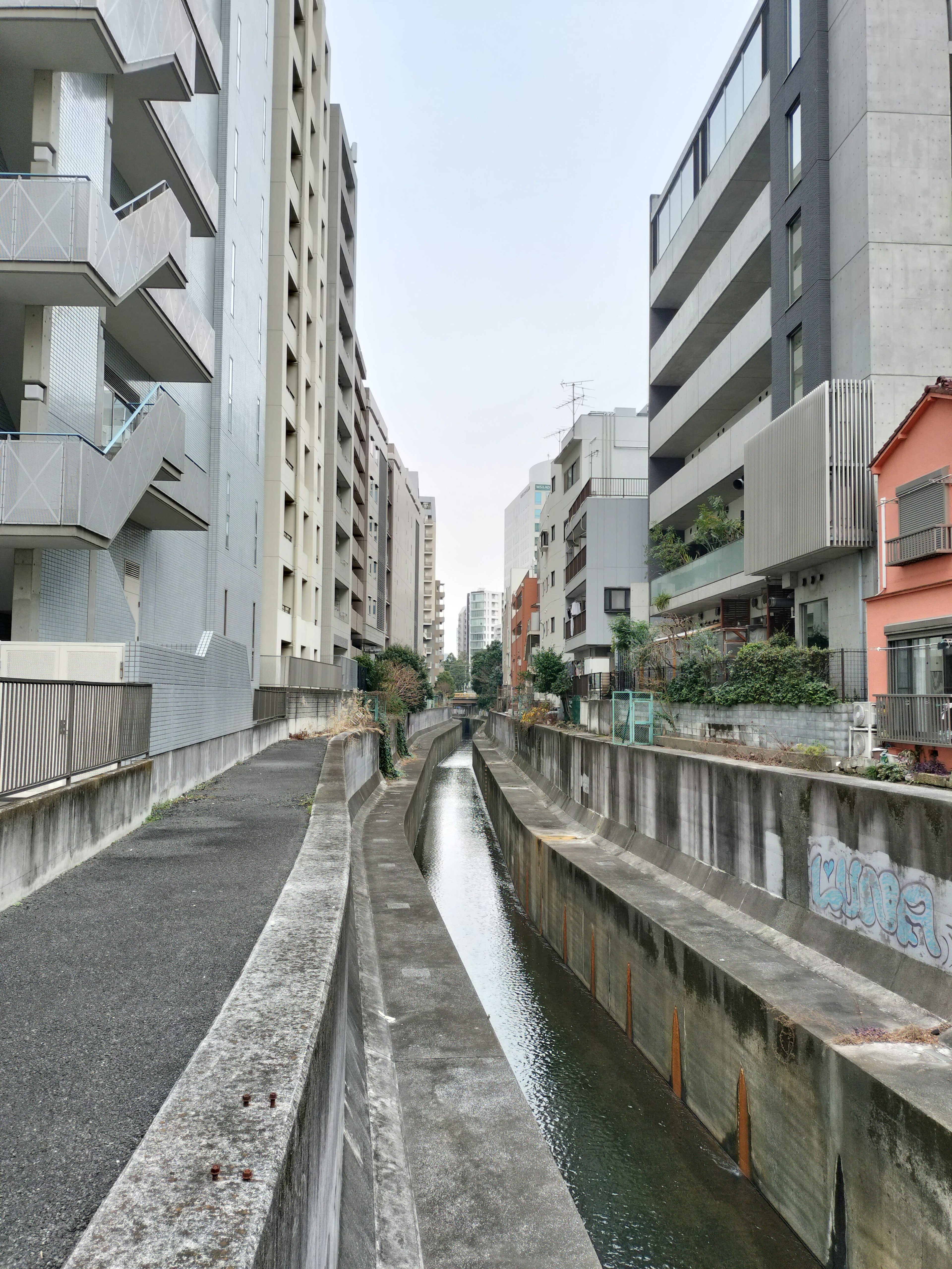 Narrow canal lined by tall buildings in an urban setting