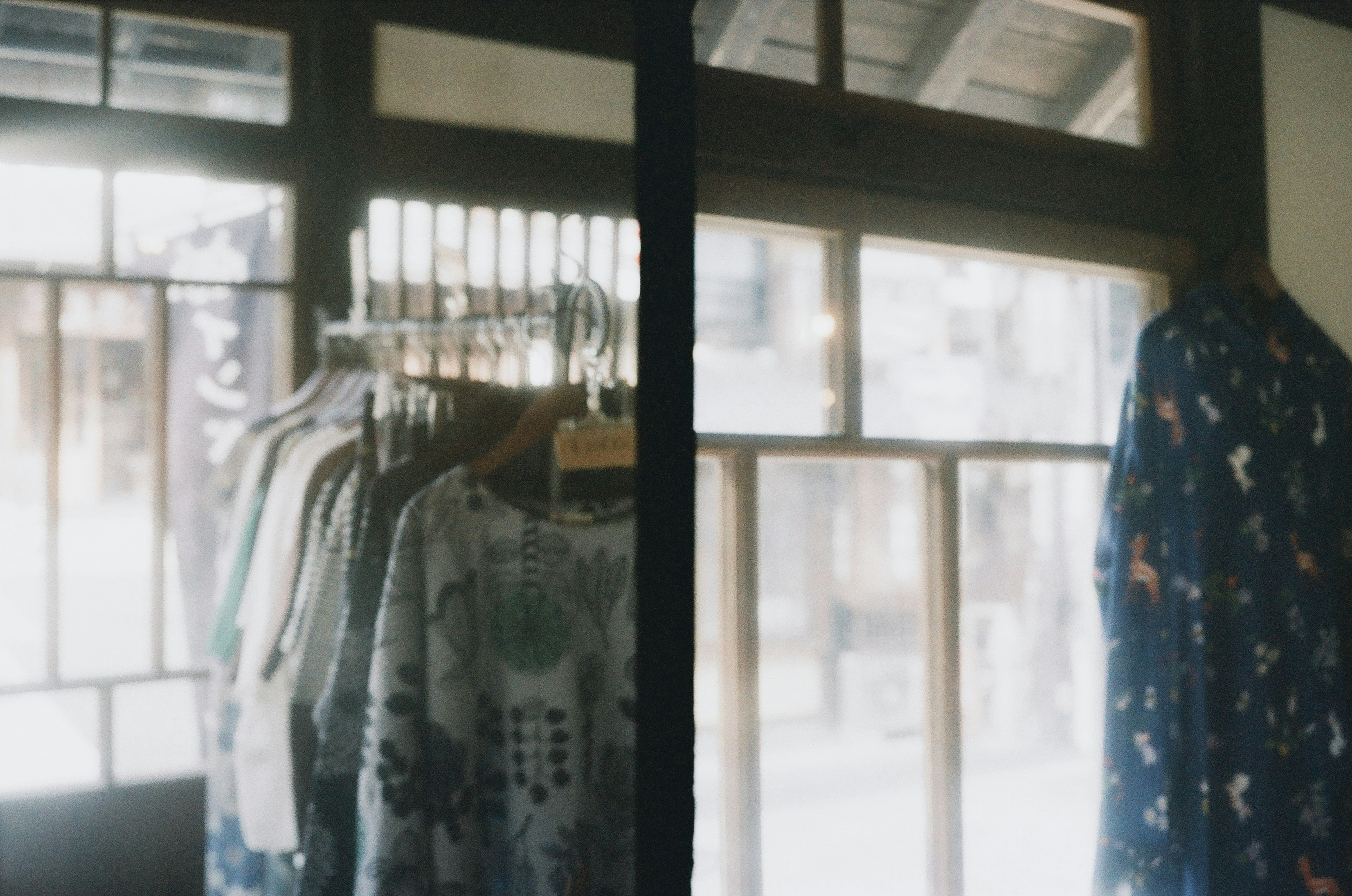 Clothing display near a bright window with wooden frames