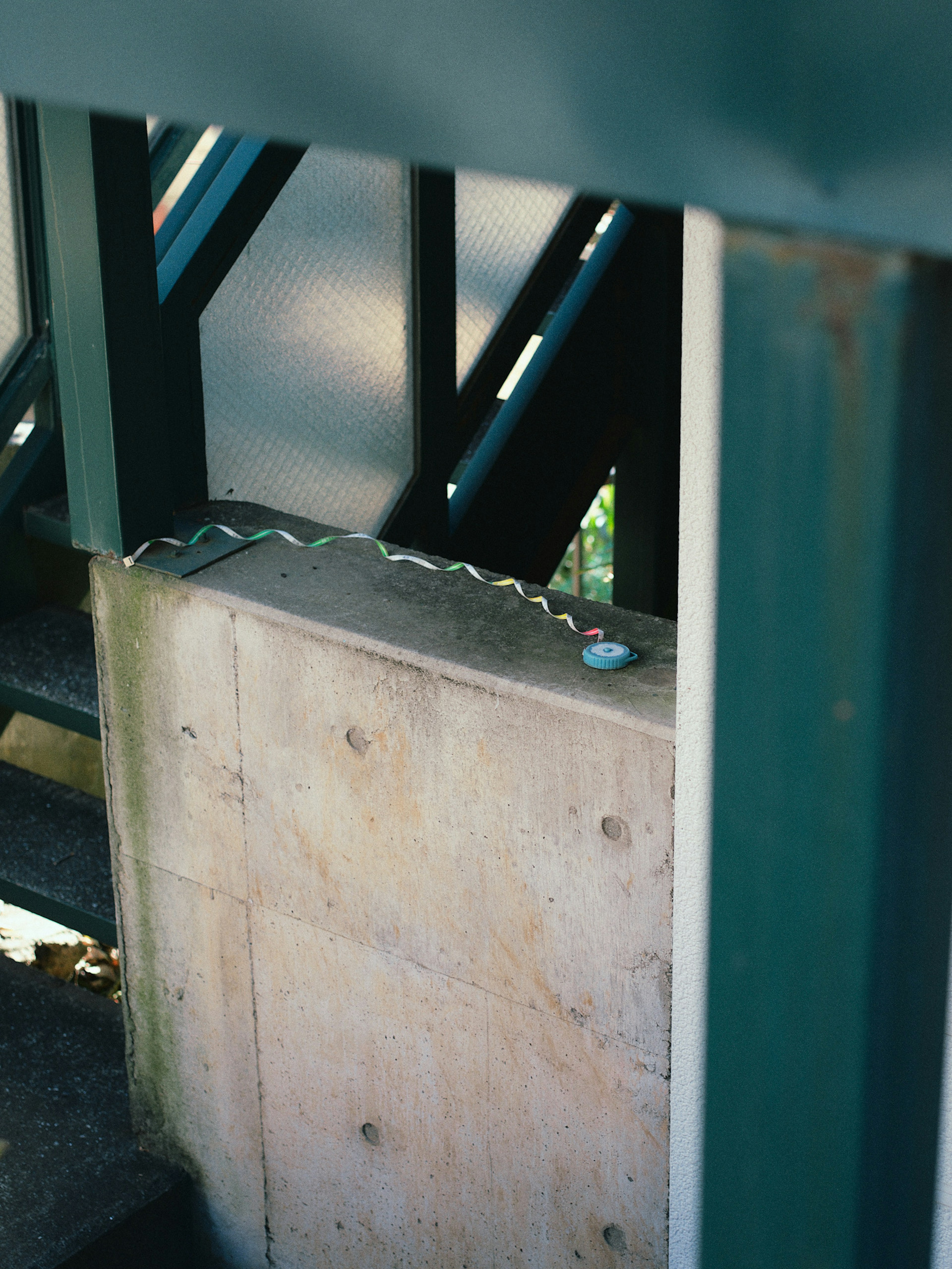 Concrete pillar and metal railing of a staircase visible in structural elements